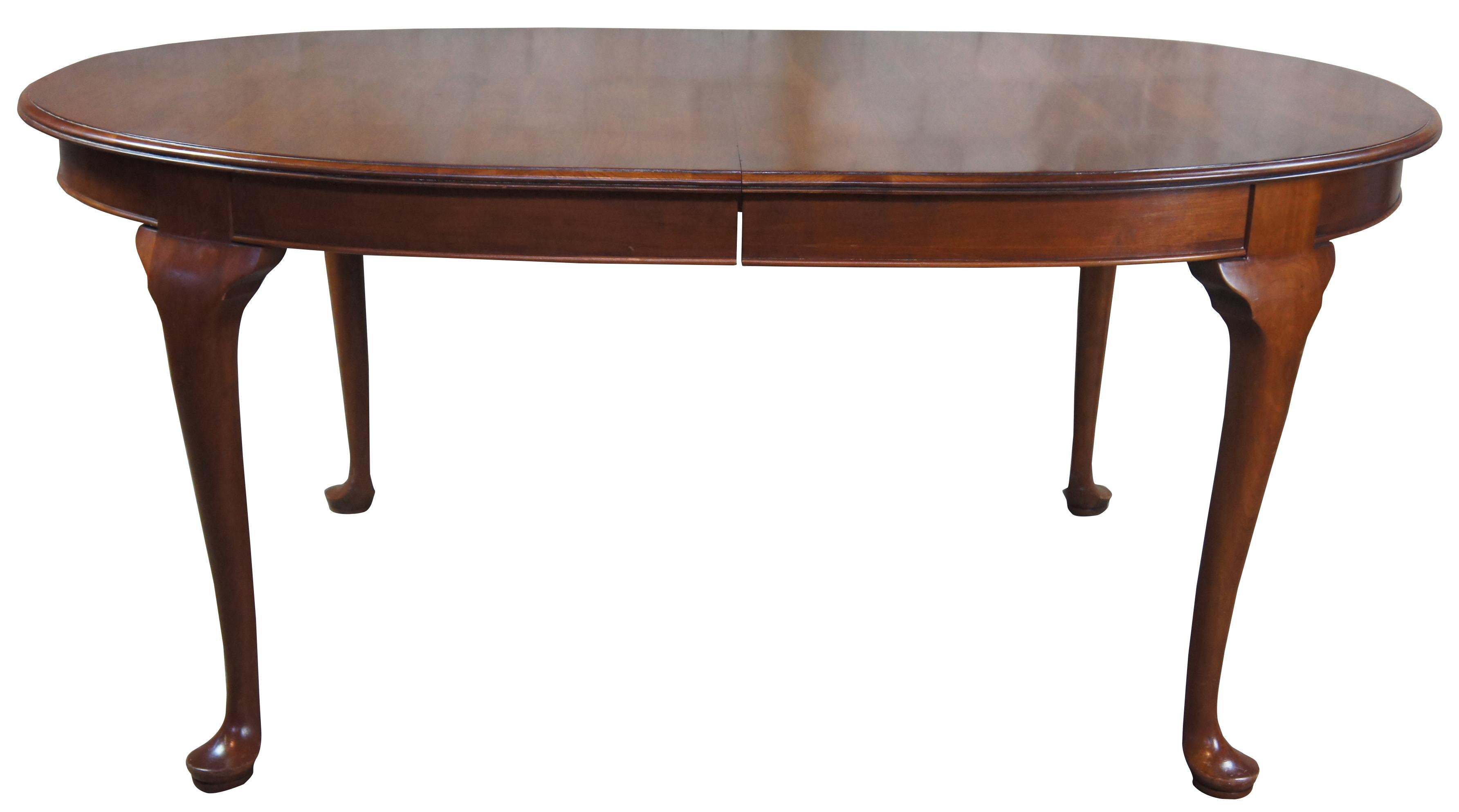 Solid cherry oval dining room table by Penn House, circa 1971. Features a Queen Anne style with cabriole legs leading to pad feet. Table pads included.