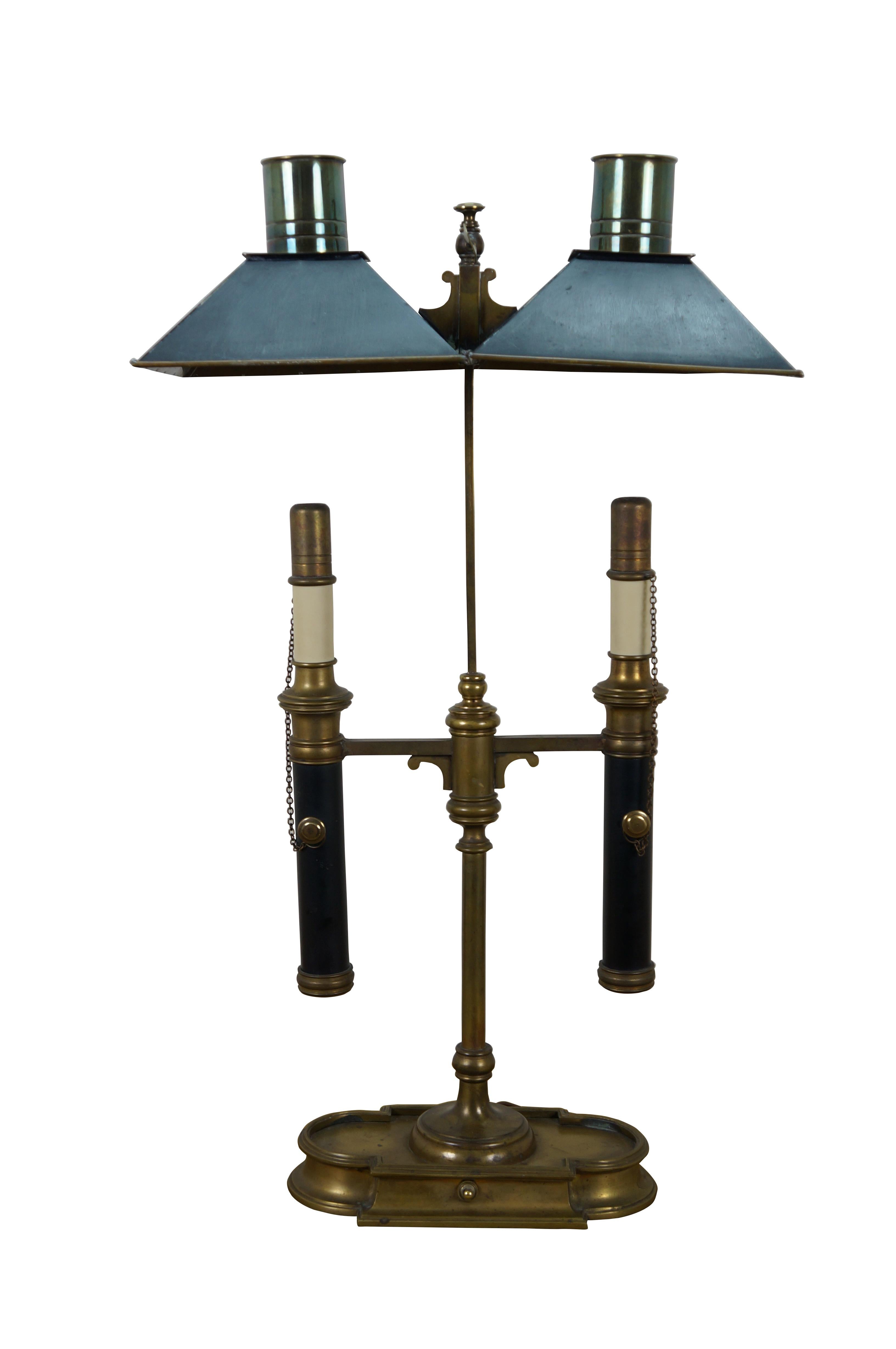 Circa 1970s Chapman brass Empire-style bouillotte two-light table lamp. Shaped like a two-arm candelabra on a lobed base with a pair of faux candlesticks with chained caps, underneath square metal shades with chimneys. Height of shades is