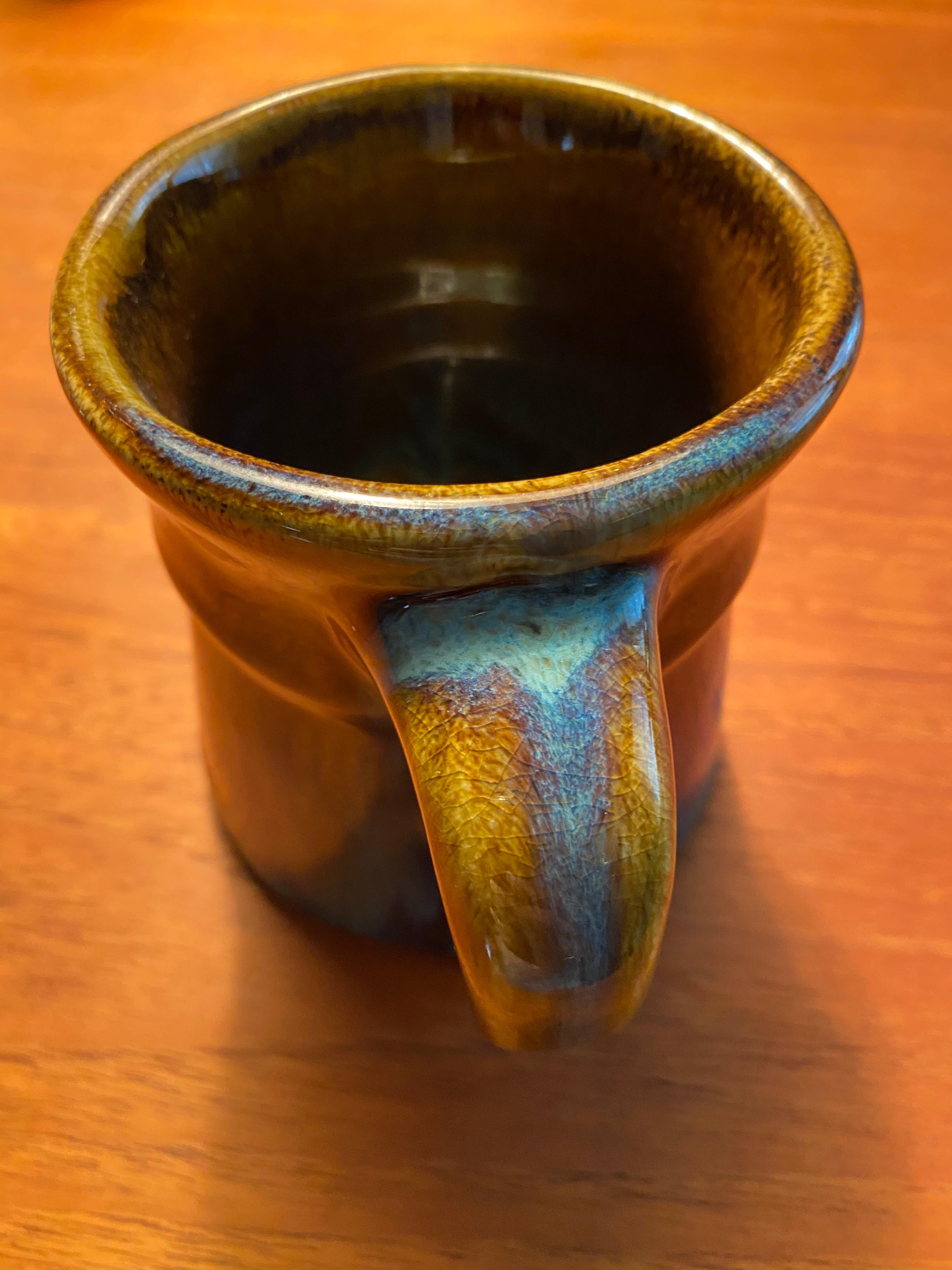 Harding black pottery coffee mug in hues of blues and browns. Signed on bottom and dated 1972. The world renowned San Antonio potter was famous for his glazes and this specimen is a fine example. No chips or cracks and perfectly functional for use