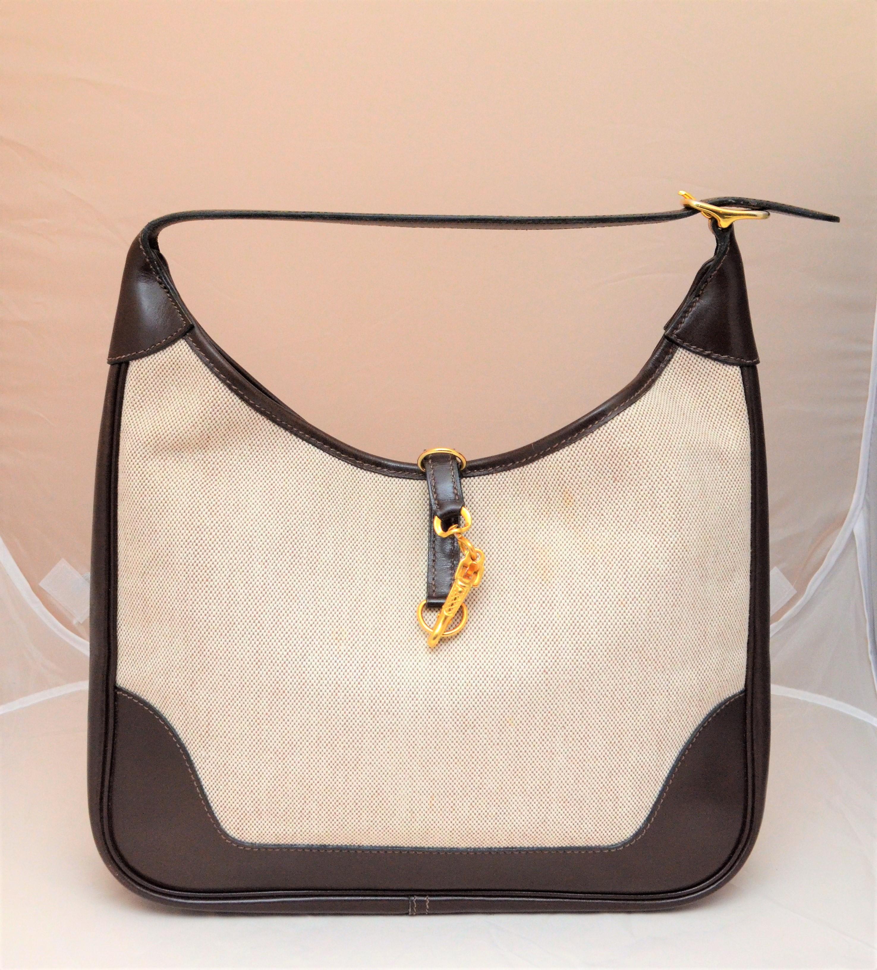 Vintage Hermes Canvas Trim Bag with Extended Shoulder Strap -- Hermes bag is featured in a neutral beige canvas color with brown leather trimmings, gold-tone clip clasp closure at the top, and an additional leather shoulder strap to extend drop