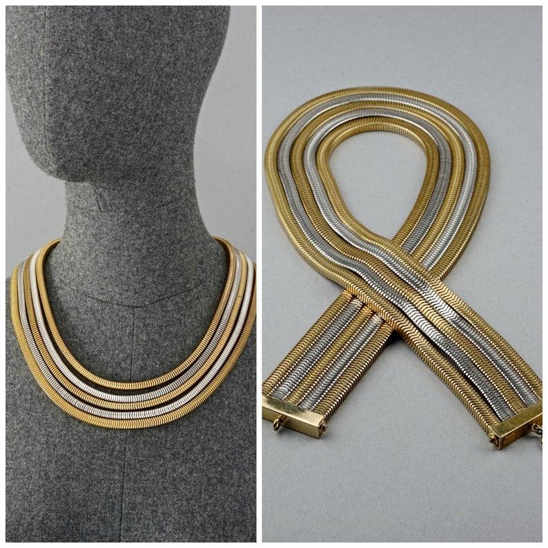 Vintage 1973 CHRISTIAN DIOR Multi Layered Two Tone Snake Chain Necklace

Measurements:
Height: 1.57 inches (4 cm)
Wearable Length: 21.06 inches (53.5 cm)

Features:
- 100% Authentic CHRISTIAN DIOR.
- 5 multi strand snake chain necklace.
- Gold and