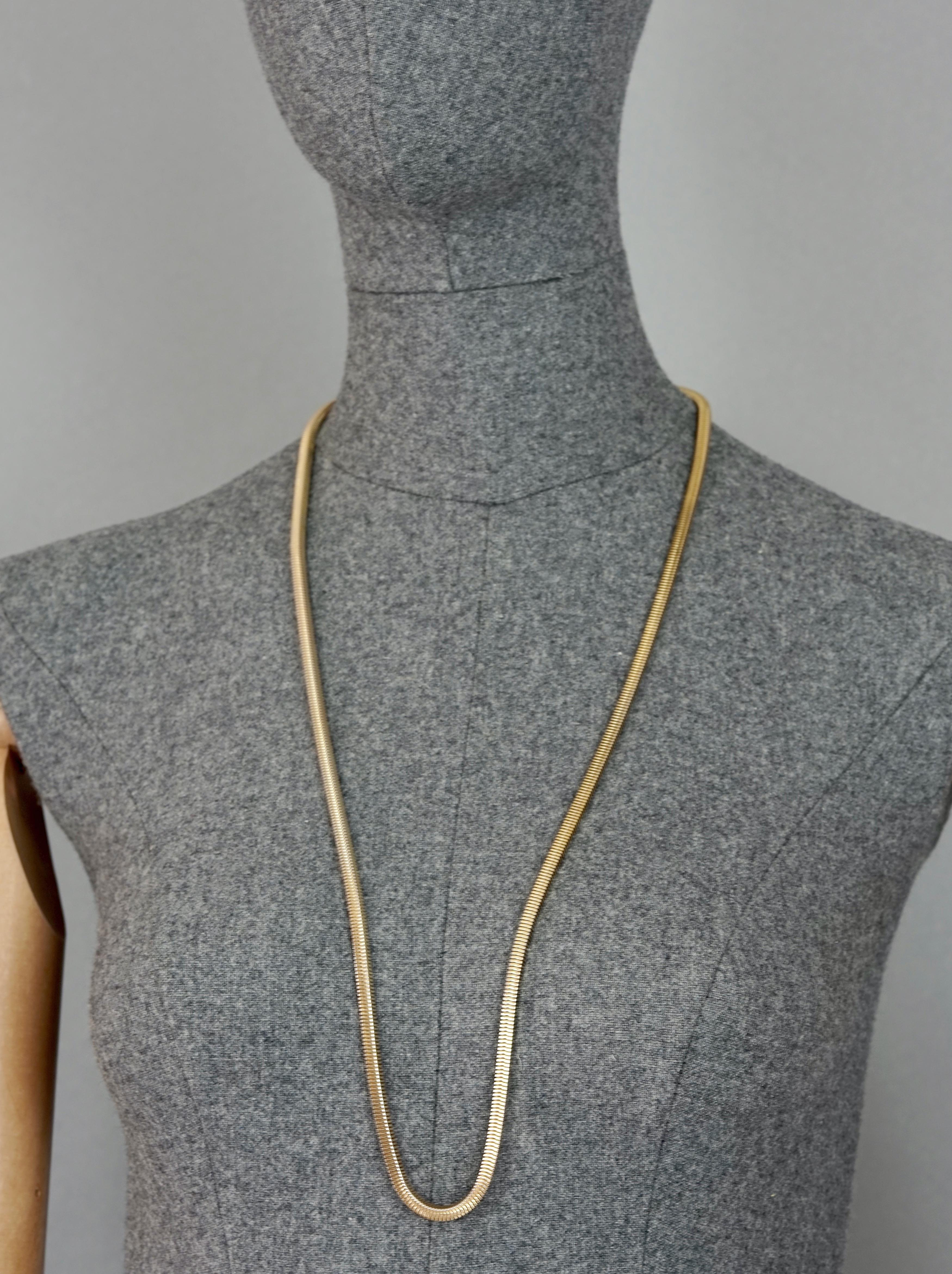 Vintage 1974 CHRISTIAN DIOR Gold Snake Chain Necklace

Measurements:
Height: 0.19 inch (0.5 cm)
Wearable Length: 32.28 inches (82 cm)

Features:
- 100% Authentic CHRISTIAN DIOR.
- Long snake chain necklace.
- Gold tone hardware.
- Signed 1974 CHR