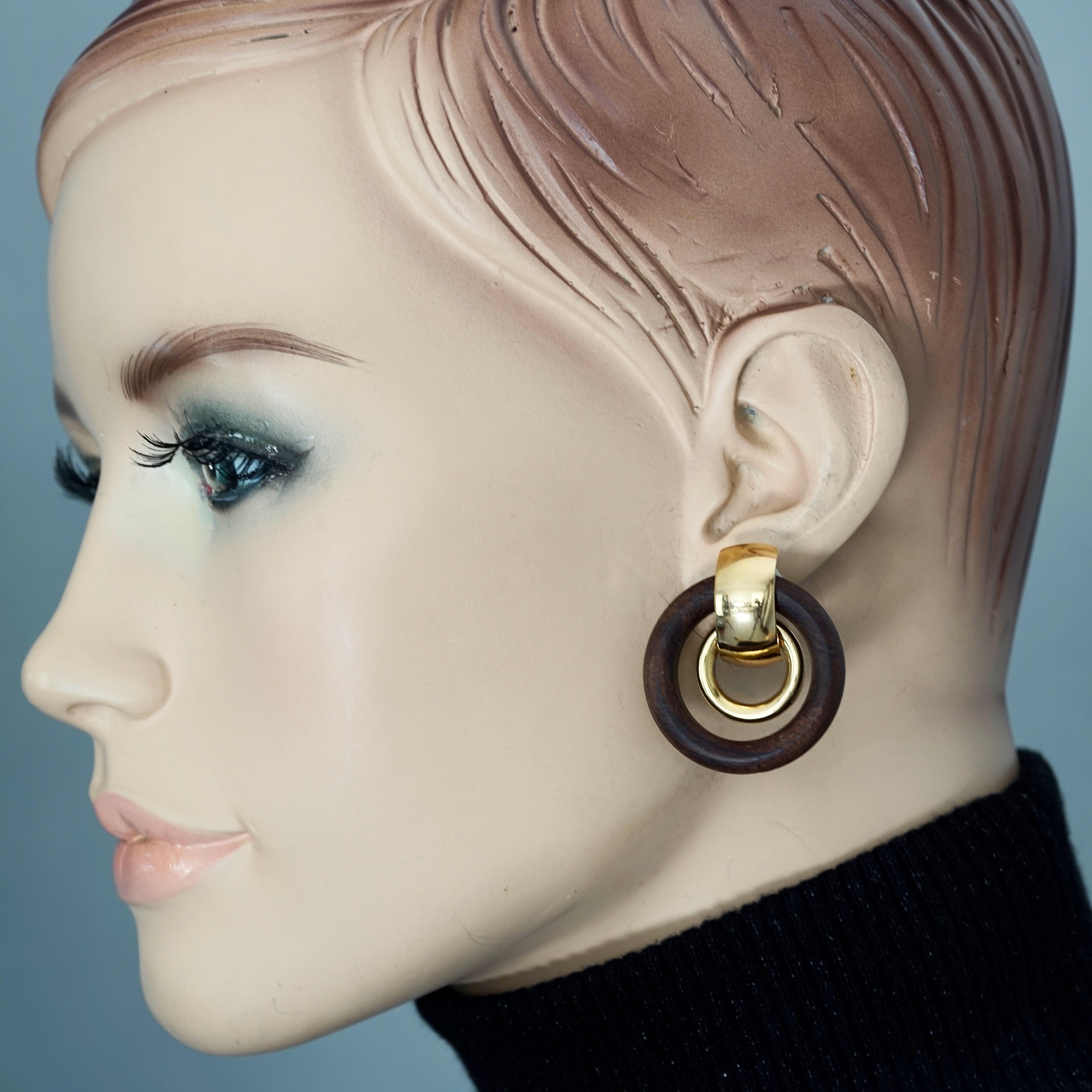 Vintage 1974 CHRISTIAN DIOR Wooden Gilt Double Hoop Earrings

Measurements:
Height: 1.42 inches (3.6 cm) 
Diameter: 1.26 inches (3.2 cm)
Weight per Earring: 8 grams

Features:
- 100% Authentic CHRISTIAN DIOR.
- Double hoop dangling earrings in wood