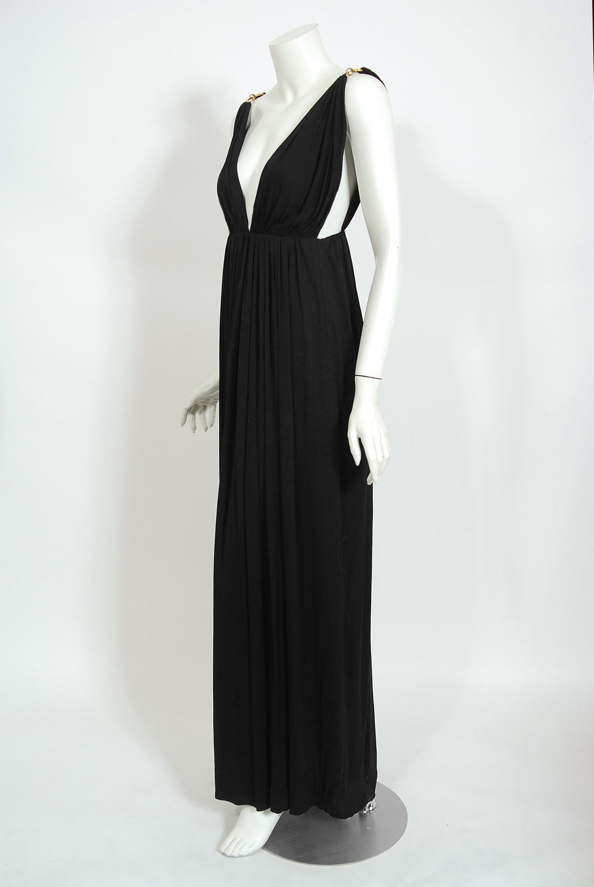 Seductive black jersey full-length maxi dress from the infamous Yves Saint Laurent Rive Gauche collection of fall-winter 1975. The same gown in navy blue in archived at the Victoria and Albert Museum in London. Pieces from this decade are very rare