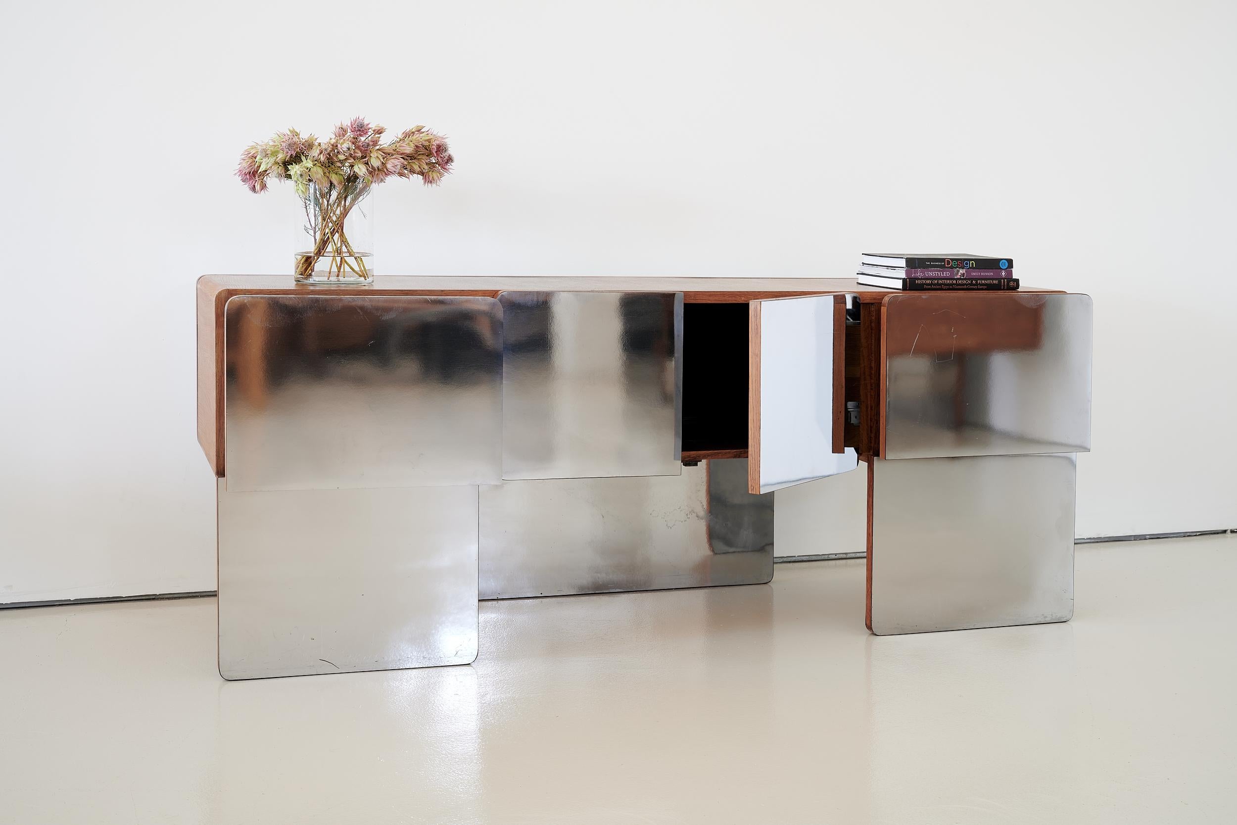 Made in Canada by Xception, Registered design 1976 (marked inside case)

Space Age

Solid wood and wood veneer

Plexiglass-like mirrored veneer on fronts of doors and drawers and backside of the console. Small area of light patina on the