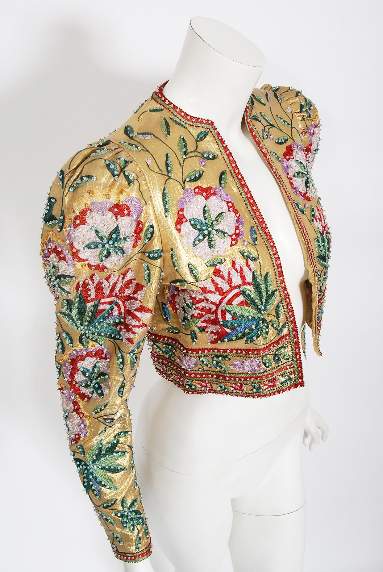 An extremely gorgeous one-of-a-kind Lanvin Haute Couture metallic gold lamé cropped jacket dating back to the late 1970's. The fabric itself is a masterpiece; sparkling gold snakeskin patterned lamé lavishly embroidered with colorful chain-stitch