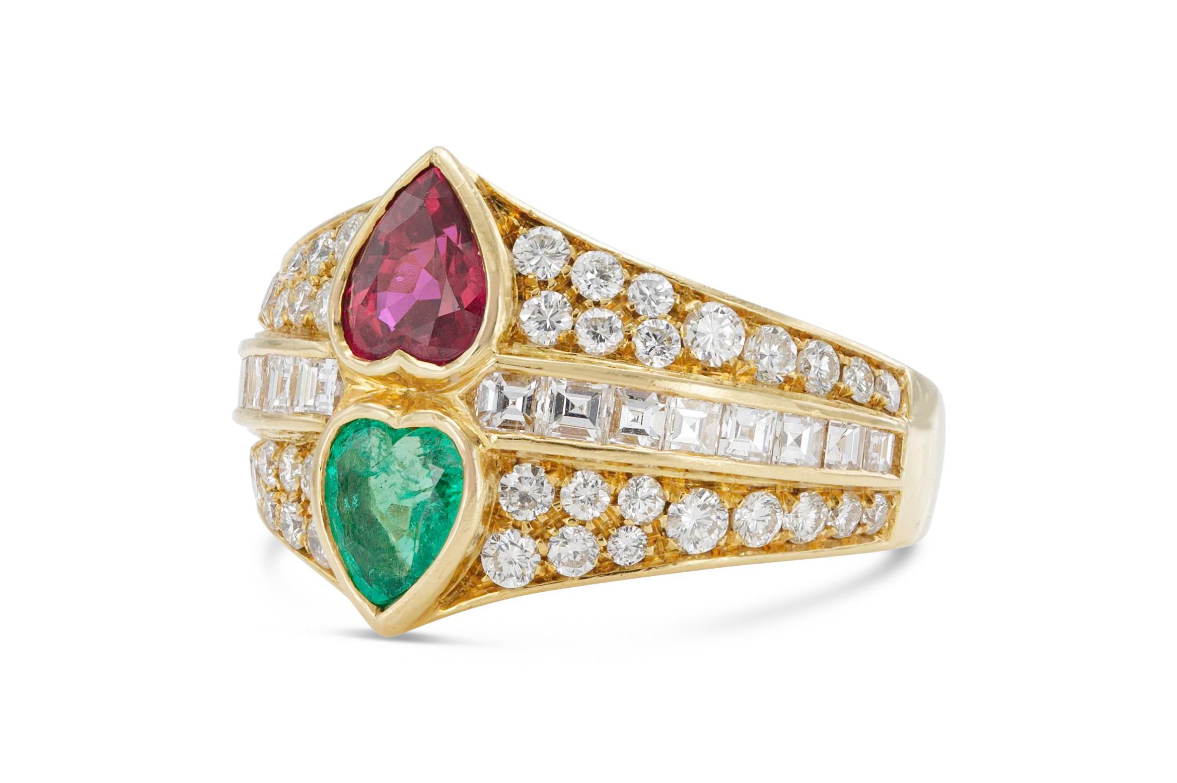Finemente realizzato in oro giallo 18 carati con un rubino a forma di cuore di circa 1,00 carati e uno smeraldo a forma di cuore di circa 0,90 carati. L'anello presenta 44 diamanti tondi Brillianti e 12 diamanti quadrati taglio Baguette per un peso