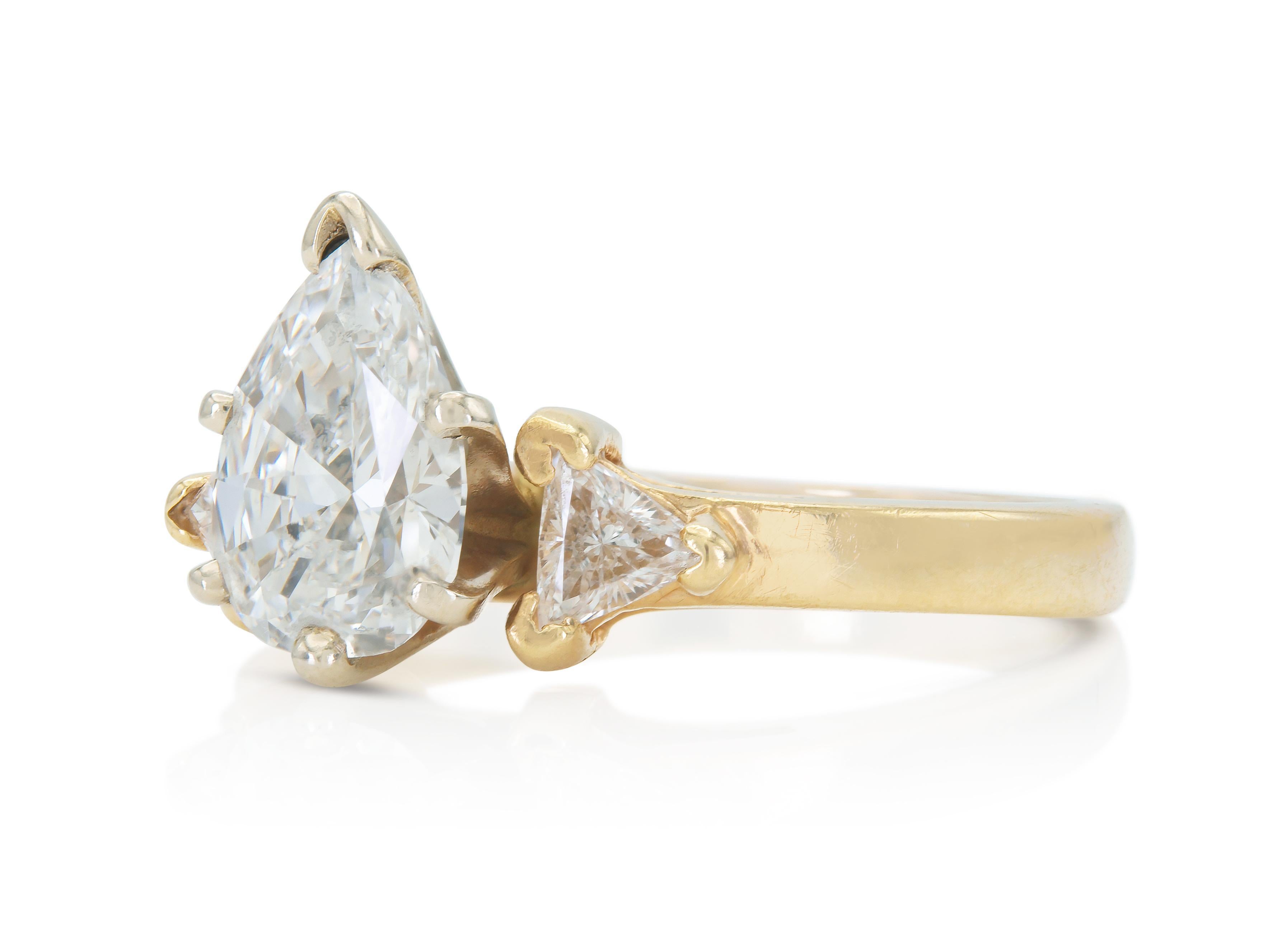 Fein in Handarbeit in 14k Gelbgold mit einem Zentrum Pear Shaped Diamond mit einem Gewicht von etwa 1,30 Karat, H-I Farbe, SI1-SI2 Klarheit, mit zwei Seiten Trillion geschnitten Diamanten mit einem Gesamtgewicht von etwa 0,30 Karat.
Circa 1980er