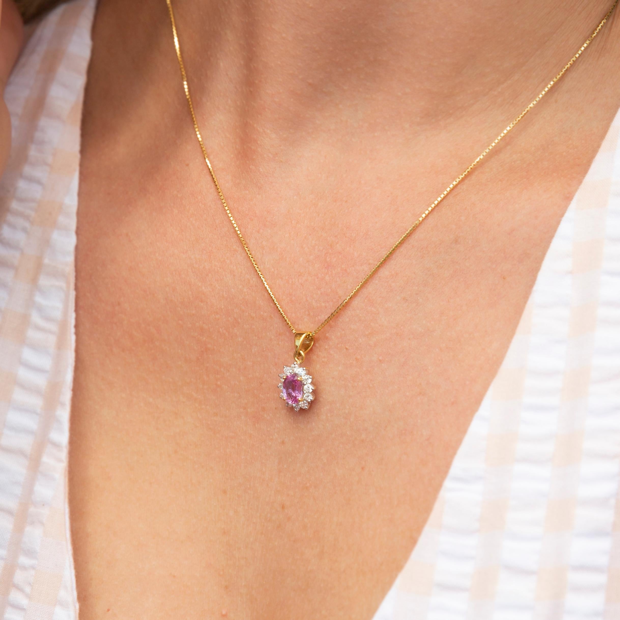 Crafted in 18 carat yellow gold, this adorable vintage pendant features a darling oval pink sapphire shimmering irresistible inside a delightful halo of twelve round brilliant cut diamonds. The Scarlet Penant hands gracefully from a lovely rabbit