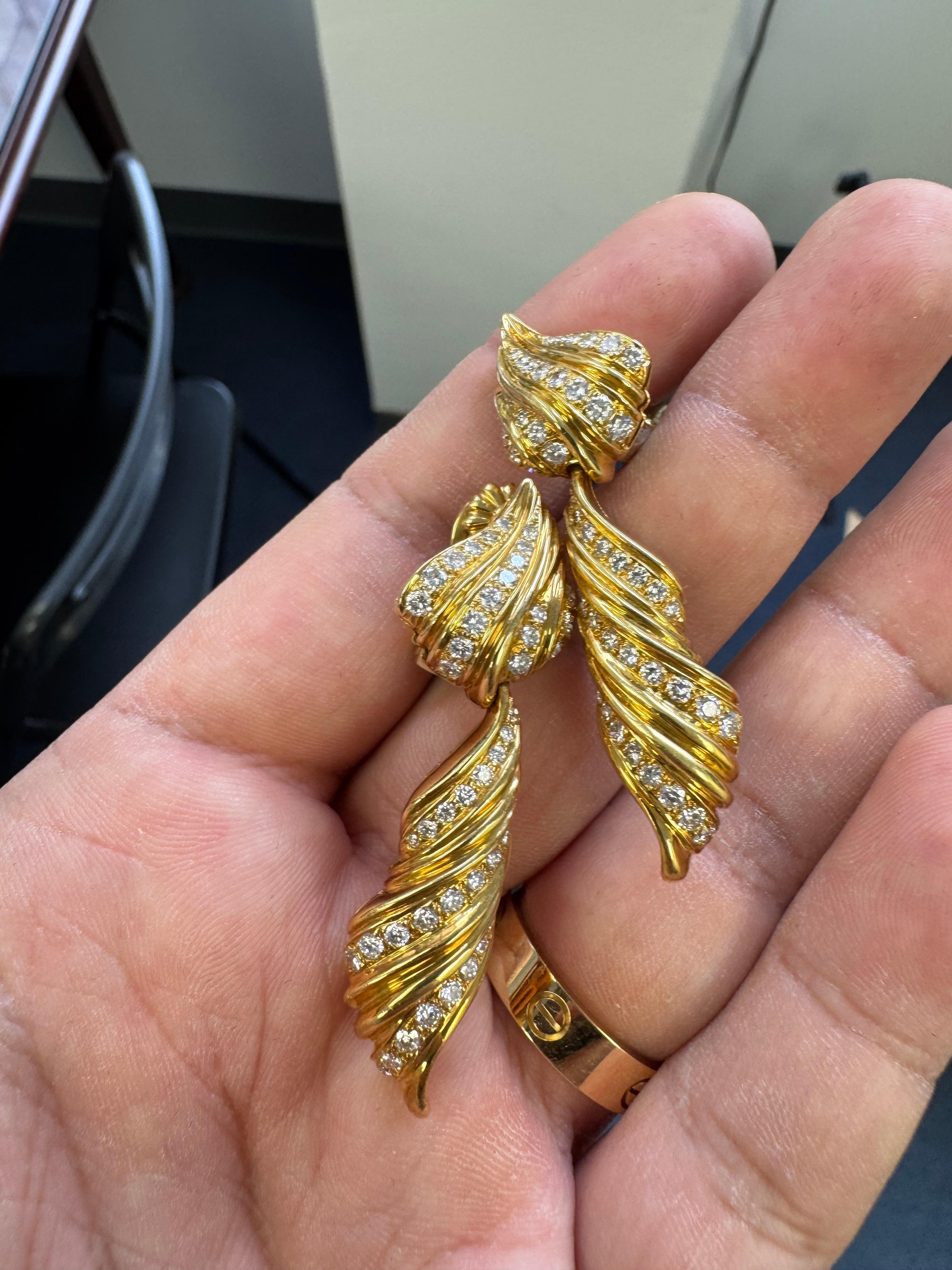 Estos atrevidos y esculturales pendientes vintage, elaborados en radiante oro amarillo de 18 quilates, presentan un dinámico diseño en espiral con pavé de finos diamantes blancos. Cada pendiente se curva elegantemente con crestas dimensionales y