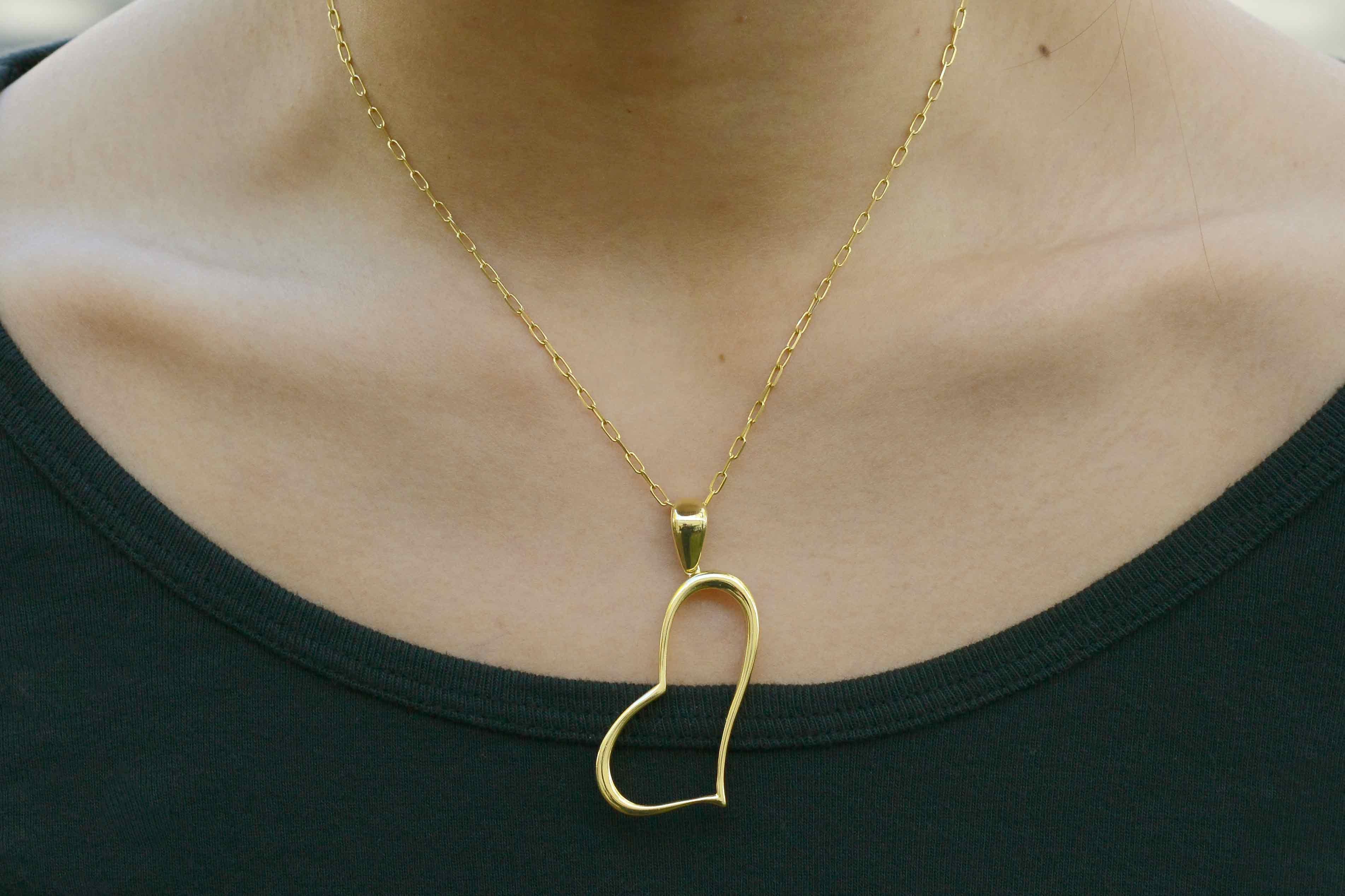 A lovingly chic 1980s vintage abstract heart pendant. A finely polished, buttery and heavy 18k yellow gold gives this bold accessory an eye catching appeal. The sizable bail (loop) allows for wearing on all widths of chains and the sleek design