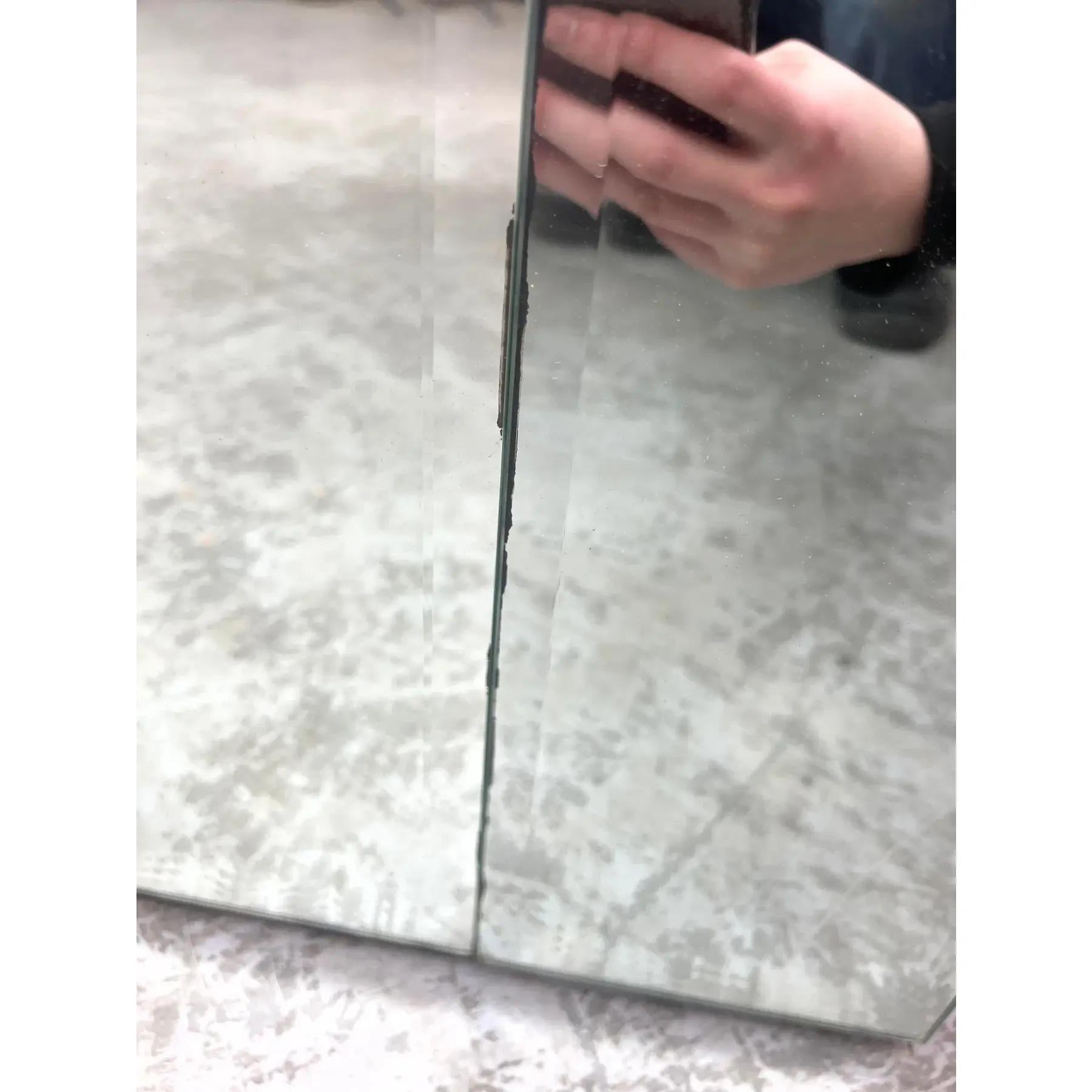 Biombo vintage de tres paneles con espejos verticales y bordes biselados. Cada panel está enmarcado y articulado para una colocación flexible. Los espejos están segmentados, lo que añade textura visual y dimensión. Adecuado como separador de