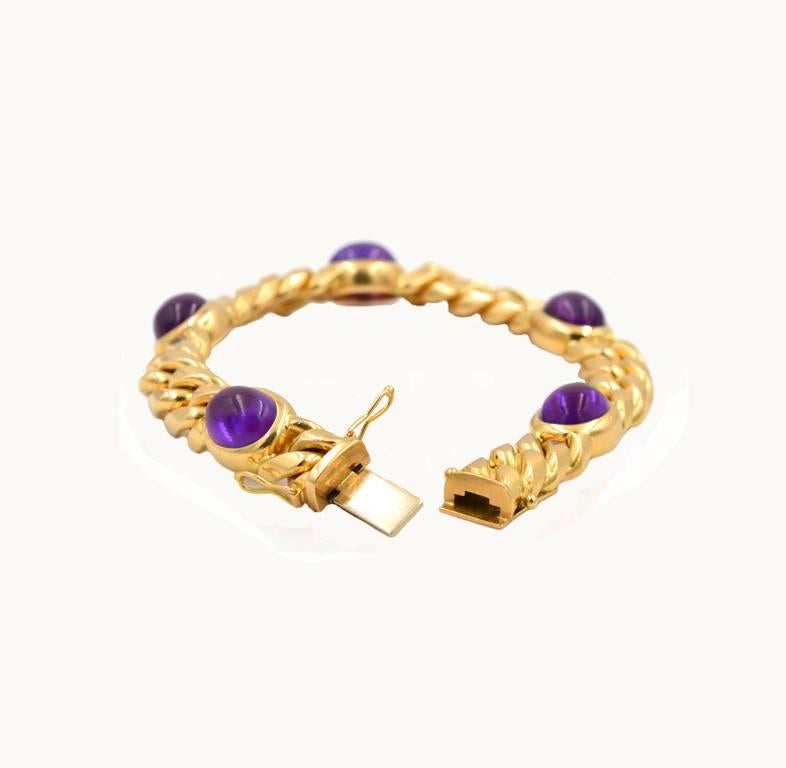 Vintage 18 karat yellow gold and amethyst link bracelet from circa 1980s.  This pretty bracelet features 5 oval amethyst cabochons (each about 9.9 mm by 7.9 mm) separated by 5 sections of curb chain gold links that lay flat against the skin.

This