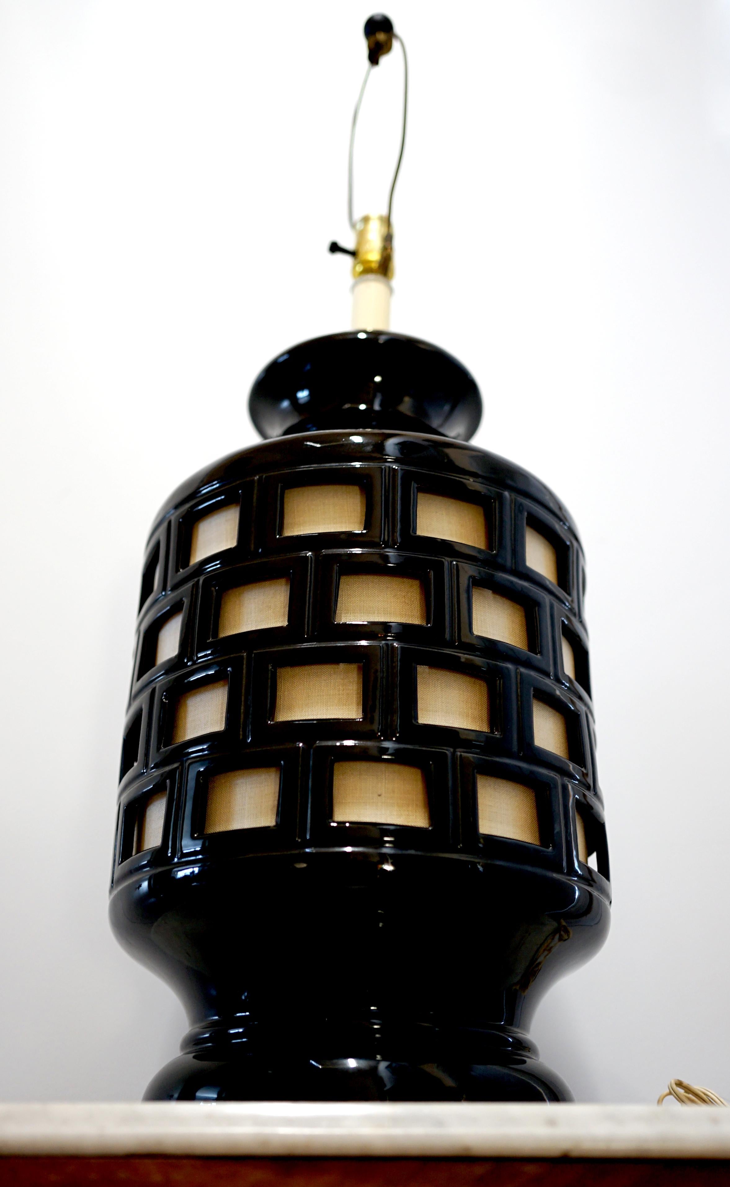 The geometric feel and sheer size of this vintage black overlaid pottery and fabric table lamp is impressive. It is the epitome of statement lighting and will become an immediate design asset in many settings. Features like the shape and high glaze