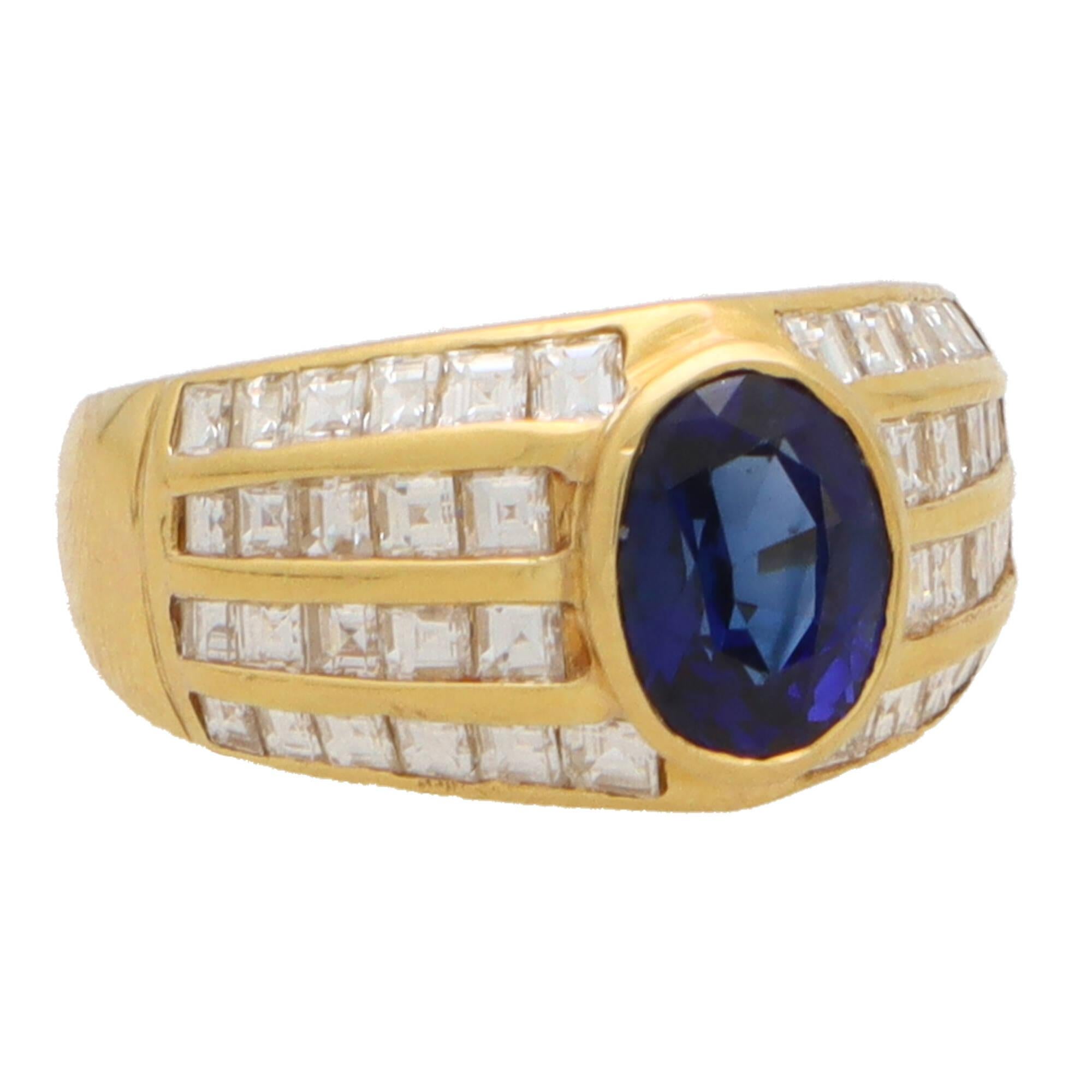  A beautiful vintage 1980's blue sapphire and diamond dress ring set in 18k yellow gold.

The ring is composed in an iconic 80's design, set centrally with an oval cut blue sapphire. The sapphire is rub over set securely in yellow gold and is
