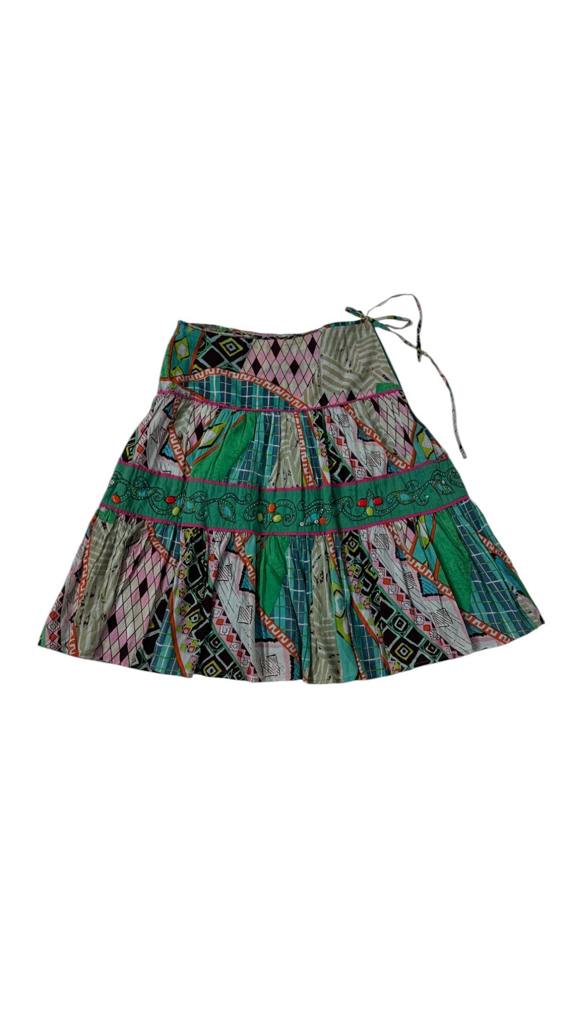 Perle rare des années 1980, cette jupe bohème vibrante de Giorgia Kauten pour Express capture l'esprit de la décennie avec ses motifs patchwork audacieux et ses détails complexes. Confectionnée en 100 % coton léger, cette jupe présente une