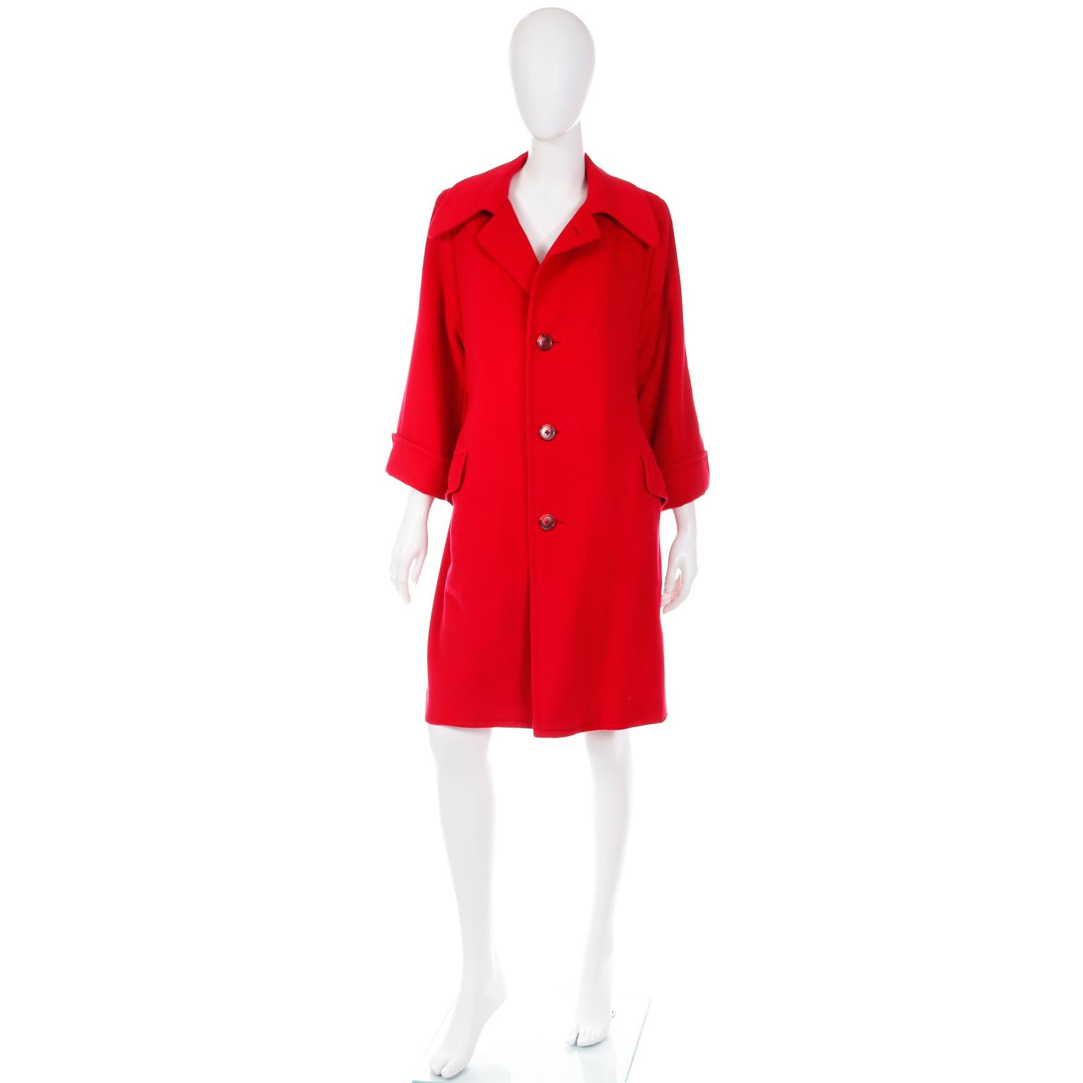 Ce magnifique manteau luxueux en cachemire, d'un rouge parfait, a été fabriqué sur mesure à Hong Kong. Le manteau a deux poches à rabat sur le devant et deux poches intérieures boutonnées. Il y a une fente de 16 pouces au centre du dos et le manteau