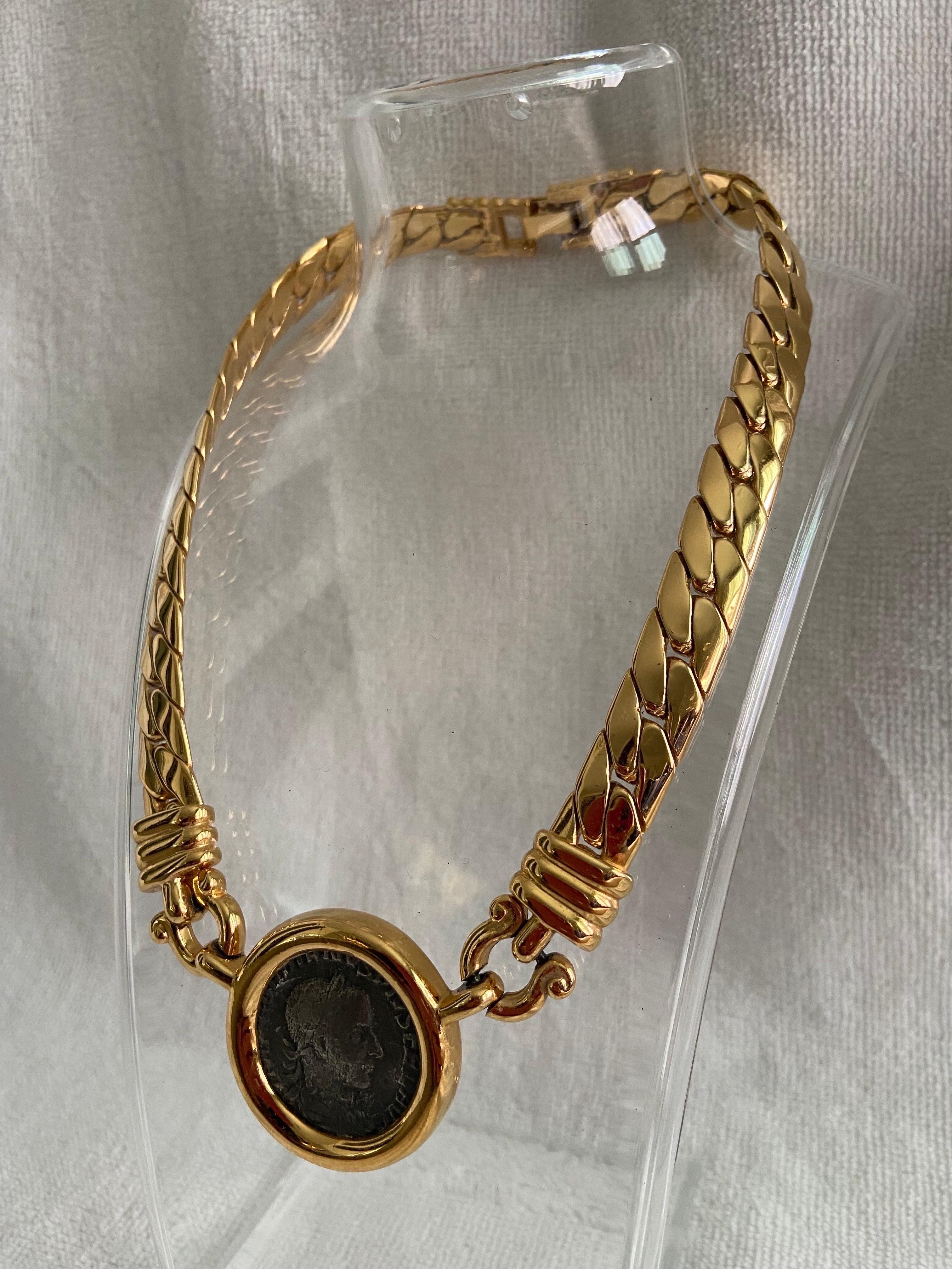 A vintage, circa 1980’s, Carolee Design faux Roman coin, gold tone Omega necklace choker. This piece is signed on the back and features a hinged clasp. The necklace is approximately 16.5” diameter. The coin is approximately 1.5” in diameter. For a
