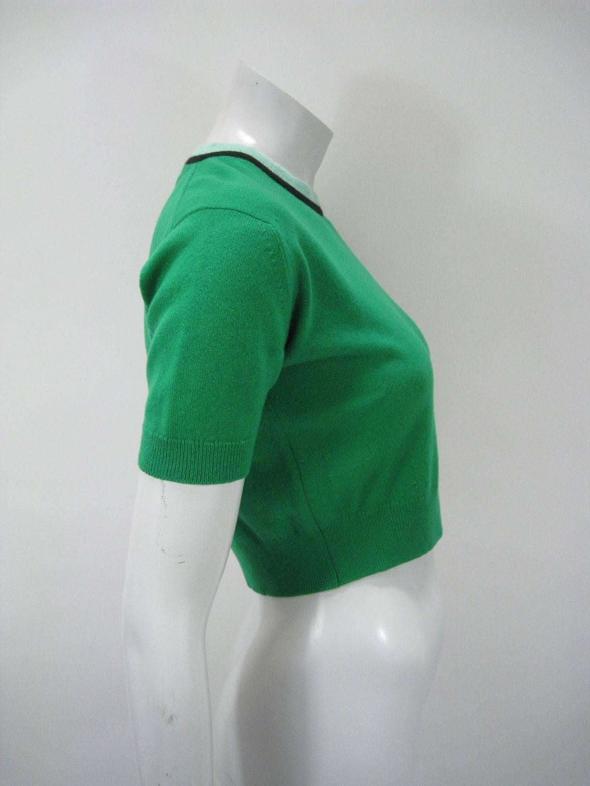 Vintage 1980's Chanel vibrant green sweater.

Cropped, fitted shape.

Short sleeves.

Ringed neckline in contrasting mint green and black.

Chanel imprinted button closure on back of neck.

No size tag.

No fabric tag, feels like wool, possibly a