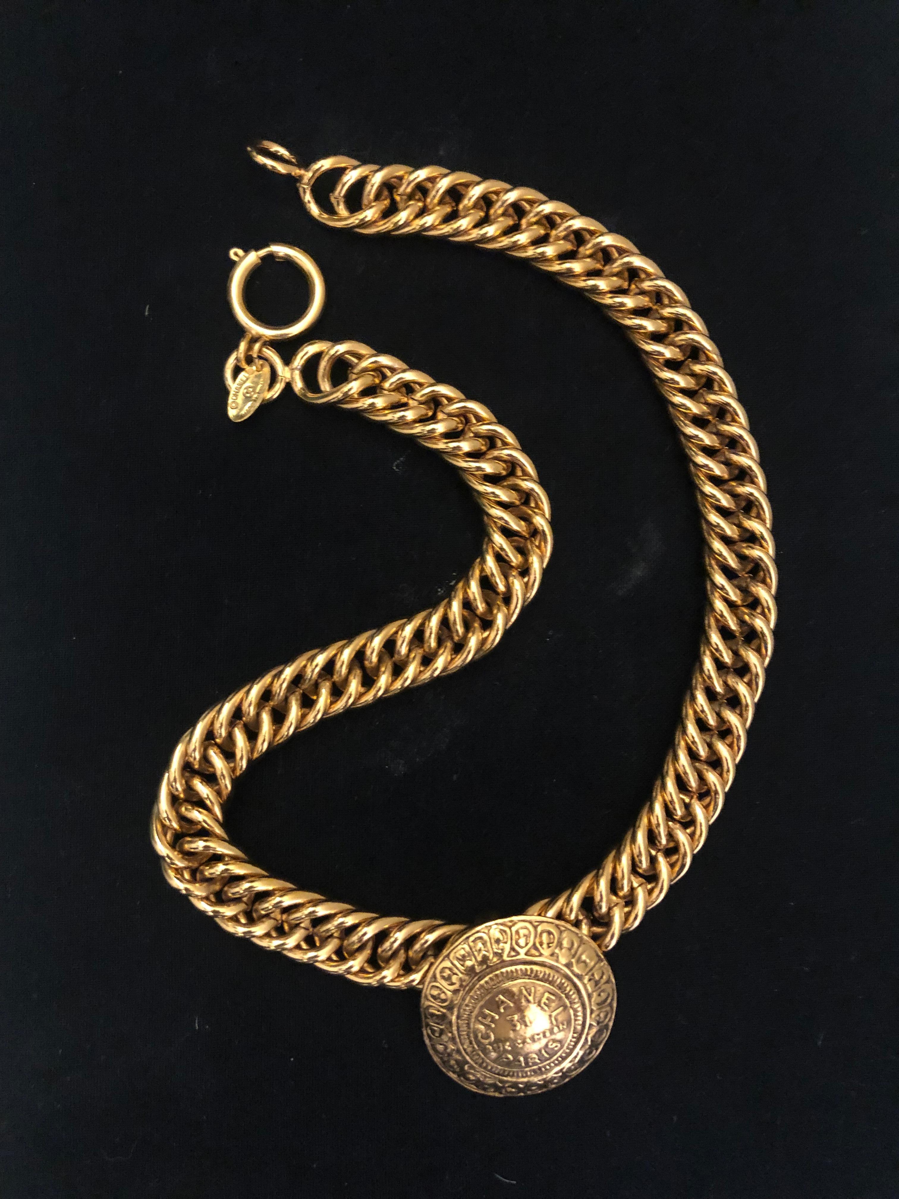 Vintage CHANEL gold toned short chain necklace featuring a 31 Rue Cambon Byzantine charm on a sturdy chain. Measures approximately 43 cm Coin 3.2 cm in diameter. Stamped Chanel made in France. Spring ring closure. Comes with box.

Condition - MINT