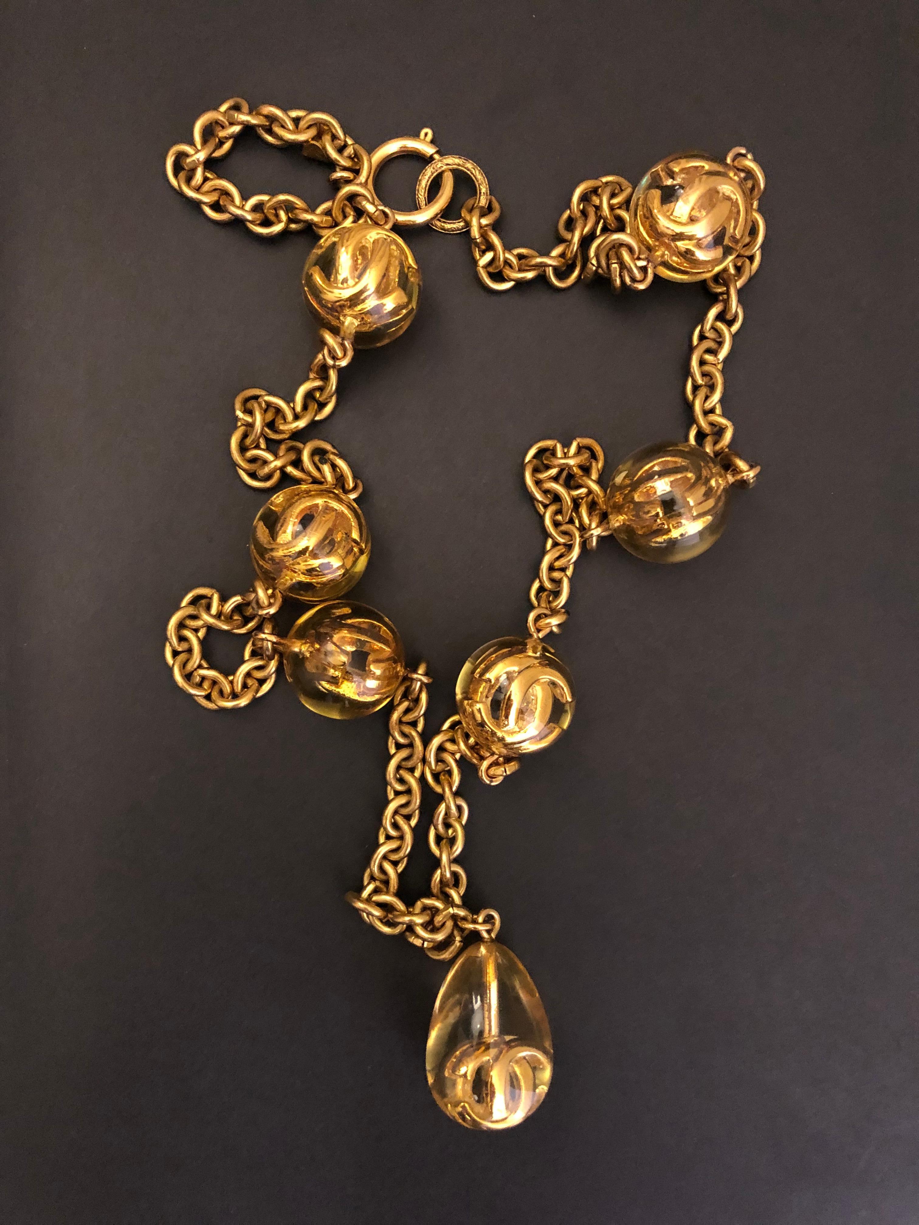 Vintage Chanel gold toned chain necklace featuring six gold toned CC logos in clear resin spheres and centered a gold toned CC logo in clear resin drop pendant. Stamp CHANEL 2 5 made in France. Chain measures approximately 80 cm. Spring ring