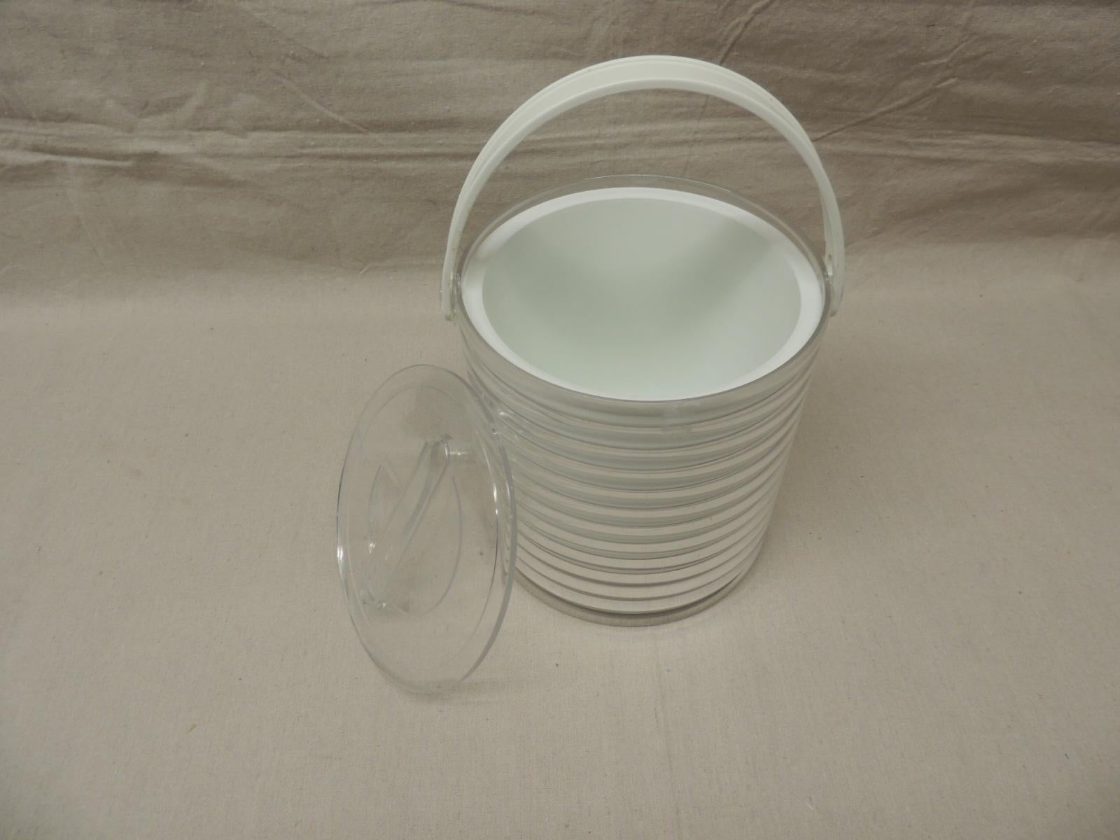A vintage, Lucite ice bucket in clear and white that is from the 1980s in America.
Measures: 9