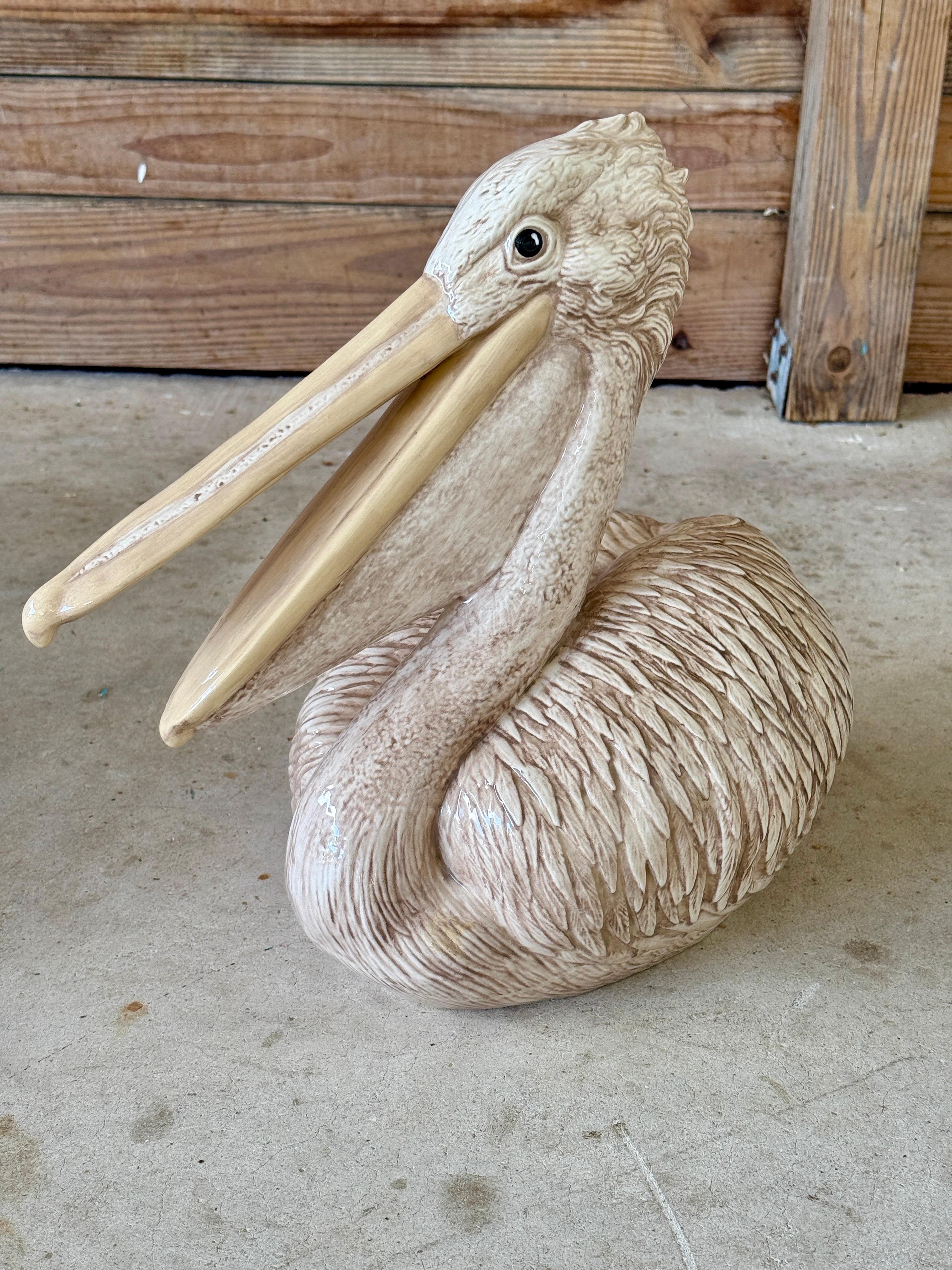 Diese charmante und skurrile Vintage-Keramikpelikan-Skulptur von Arnel's stammt aus dem Jahr 1985 und fängt mit ihrer sanften beige-cremefarbenen Glasur eine entspannte Küstenatmosphäre ein. Dieses wunderschöne Stück mit strukturierten Federn und