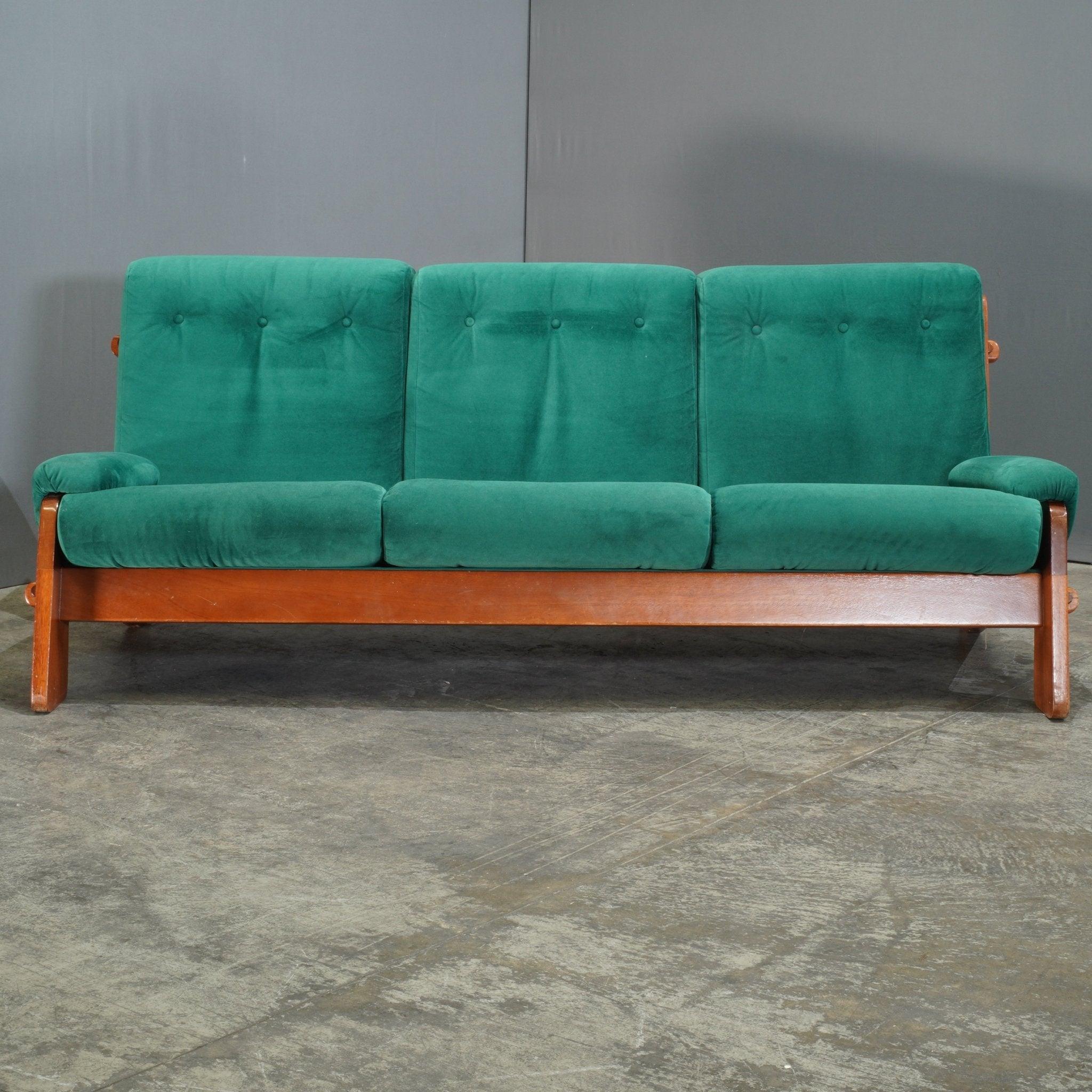 Le canapé 3 places danois vintage des années 1980 est une pièce remarquable qui allie l'esthétique rétro à l'artisanat scandinave. Revêtu d'un velours vert luxuriant, le canapé respire la chaleur et le style, tandis que le cadre en bois massif offre