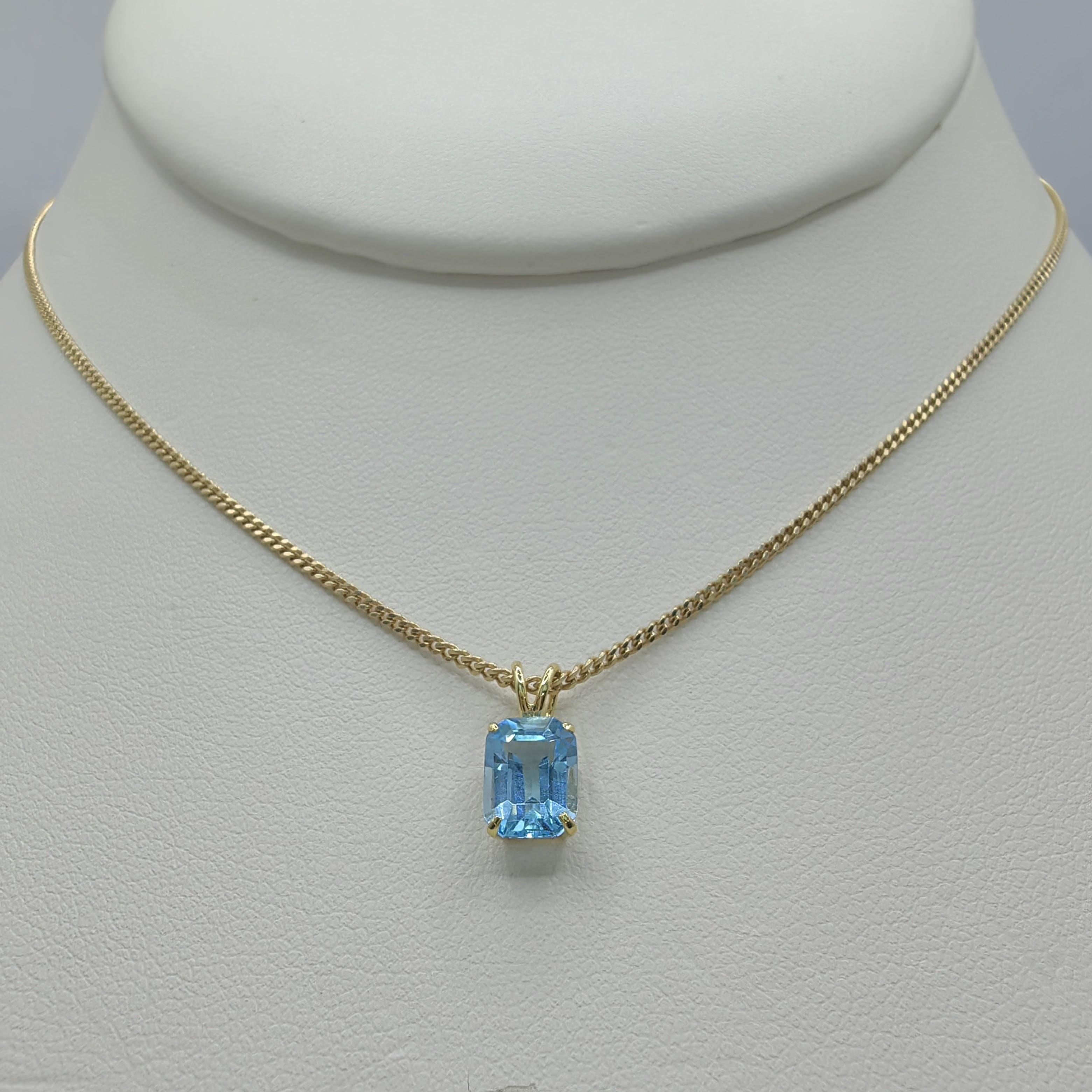 Introducing our Vintage 1980's Emerald Cut Blue Topaz Necklace Pendant in 14K Yellow Gold, a timeless piece that exudes elegance and sophistication. This exquisite pendant showcases an emerald cut blue topaz gemstone, measuring 7.79mm x 5.48mm, with