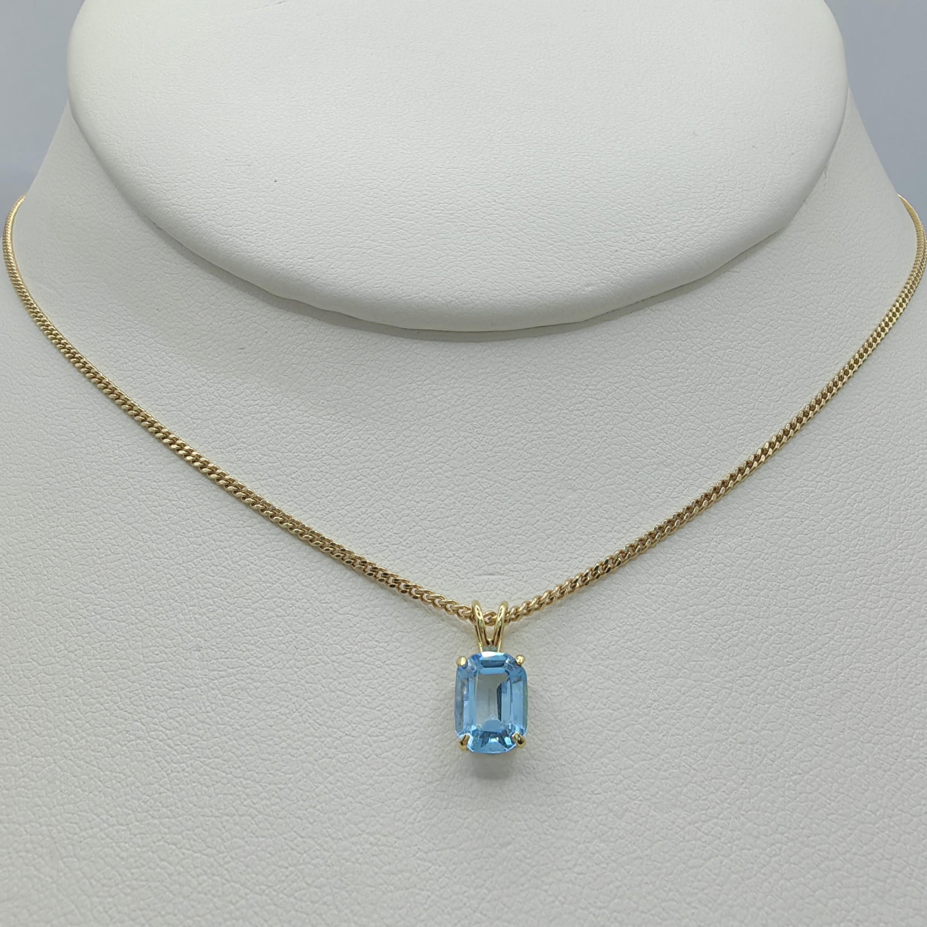 Nous vous présentons notre collier pendentif Topaze bleue taille émeraude des années 1980 en or jaune 14 carats, une pièce intemporelle qui respire l'élégance et la sophistication. Ce pendentif exquis met en valeur une topaze bleue de taille