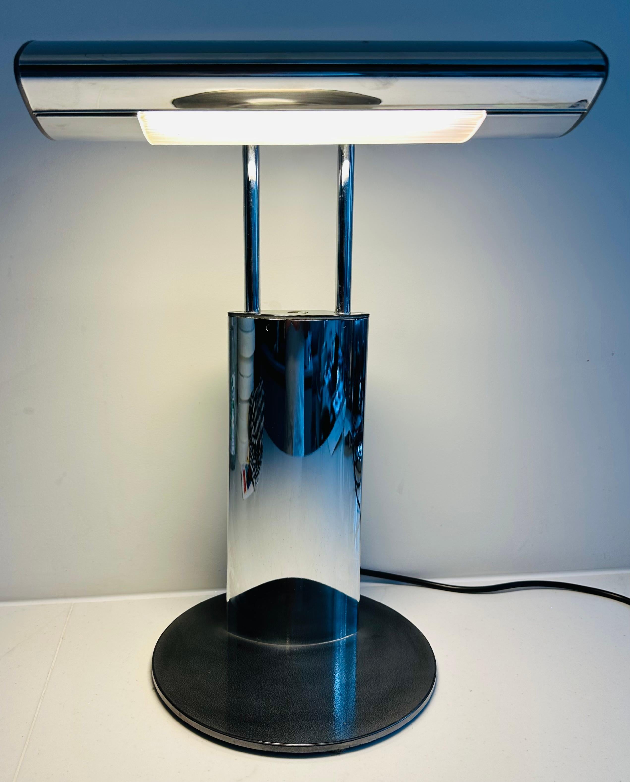 Vintage 1980s German attributed to Wofi Leuchten GMBH chrome and black lacquered adjustable light desk lamp.  The on/off switch is situated between the two upright rods which hold the light canopy.  The lightbulb is situated behind a plastic ribbed