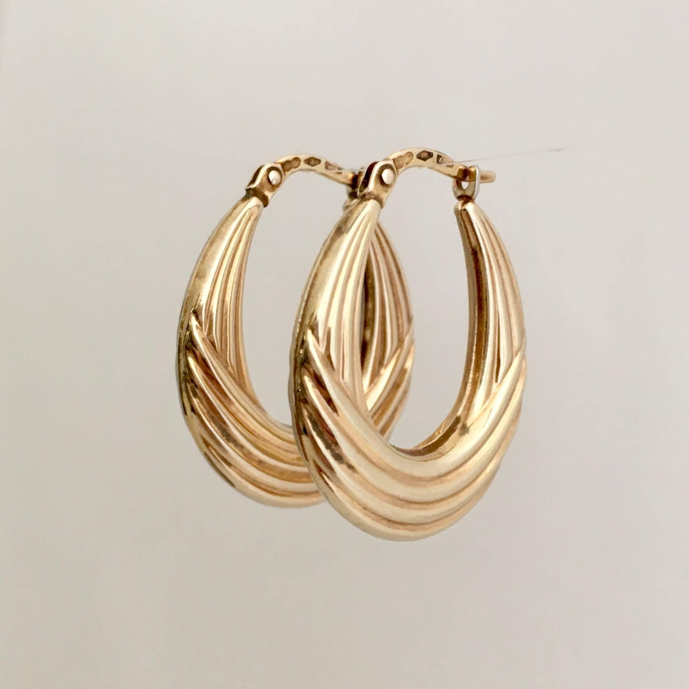 An incredibly stylish and smart pair of vintage 9ct gold hoops with a moulded ribbed design. They are a useful, everyday size at 2.8cm and they are hollow, so lightweight and wearable. The fastening clicks securely in place. 

