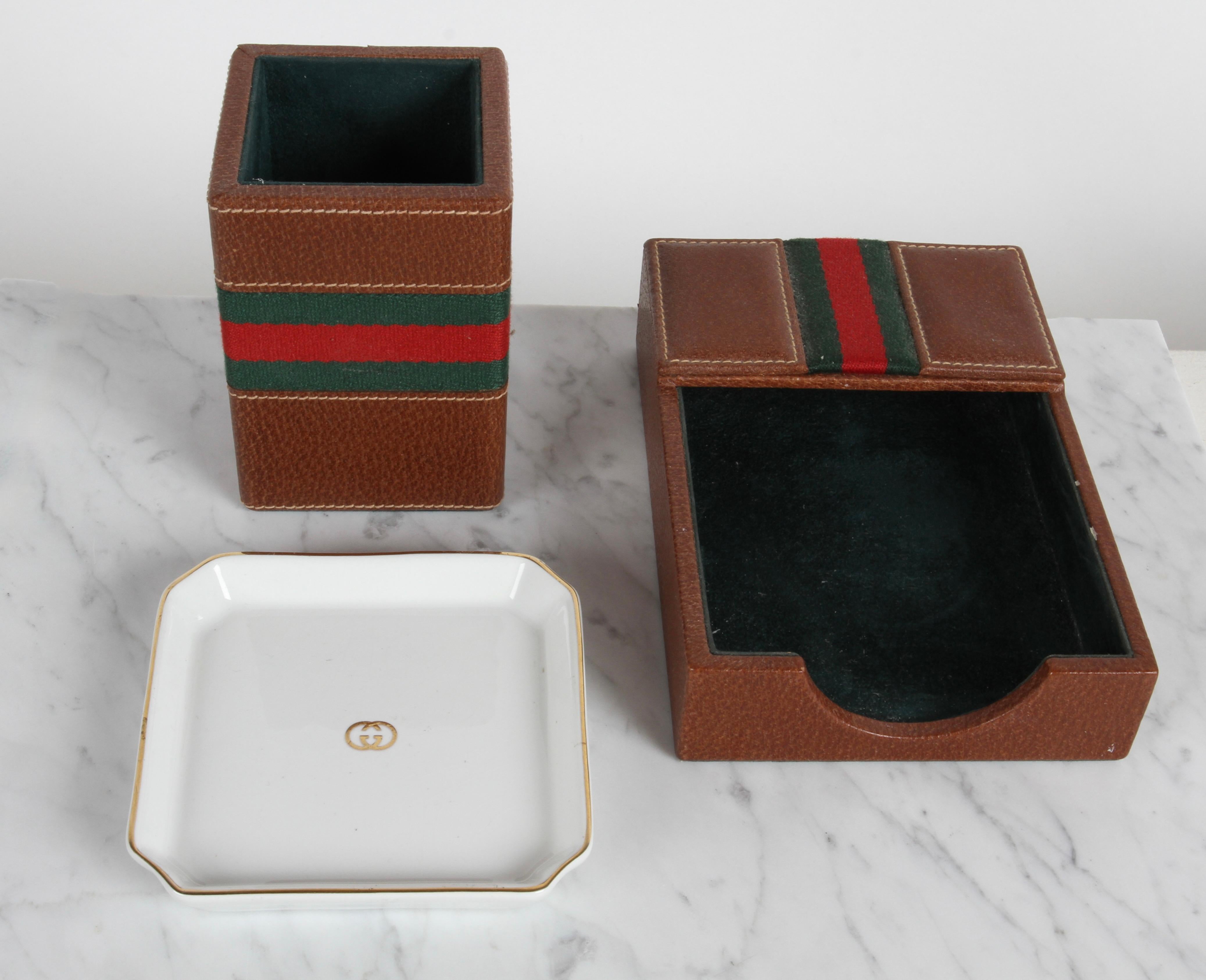Nice 1980s Gucci - Italy designed leather desk accessories set, includes pen holder, note paper holder and small tray. The leather pieces have the classic green and red stripe, with green suede interiors, the tray trimmed in gold with GG logo. 