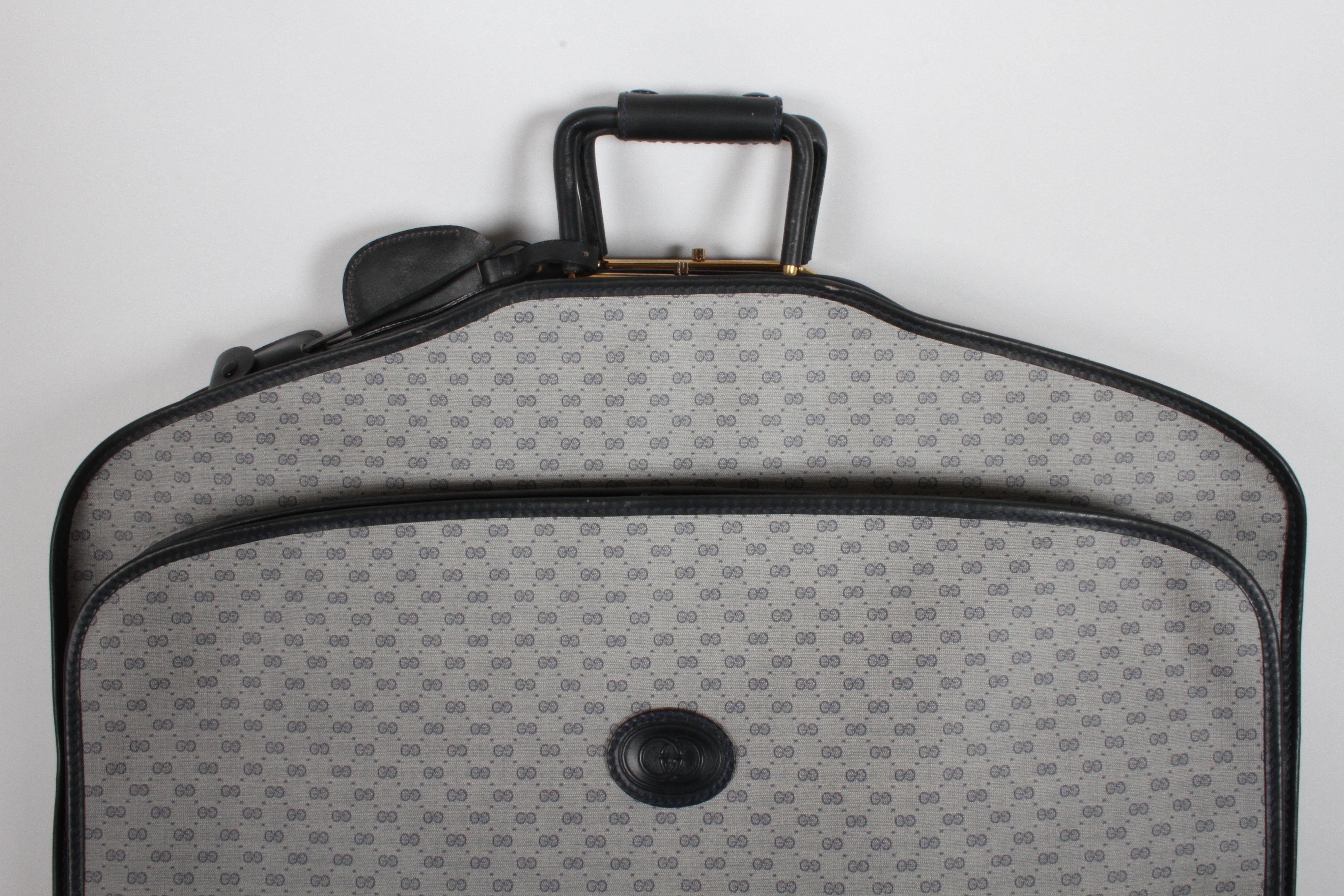 Travel in style with the beautiful vintage 1980s Gucci Luggage carry on garment bag in classic ad iconic navy GG monogram canvas with navy leather trim and dual handles. Appears to never have been used, still has the paper stuffing, no wear from