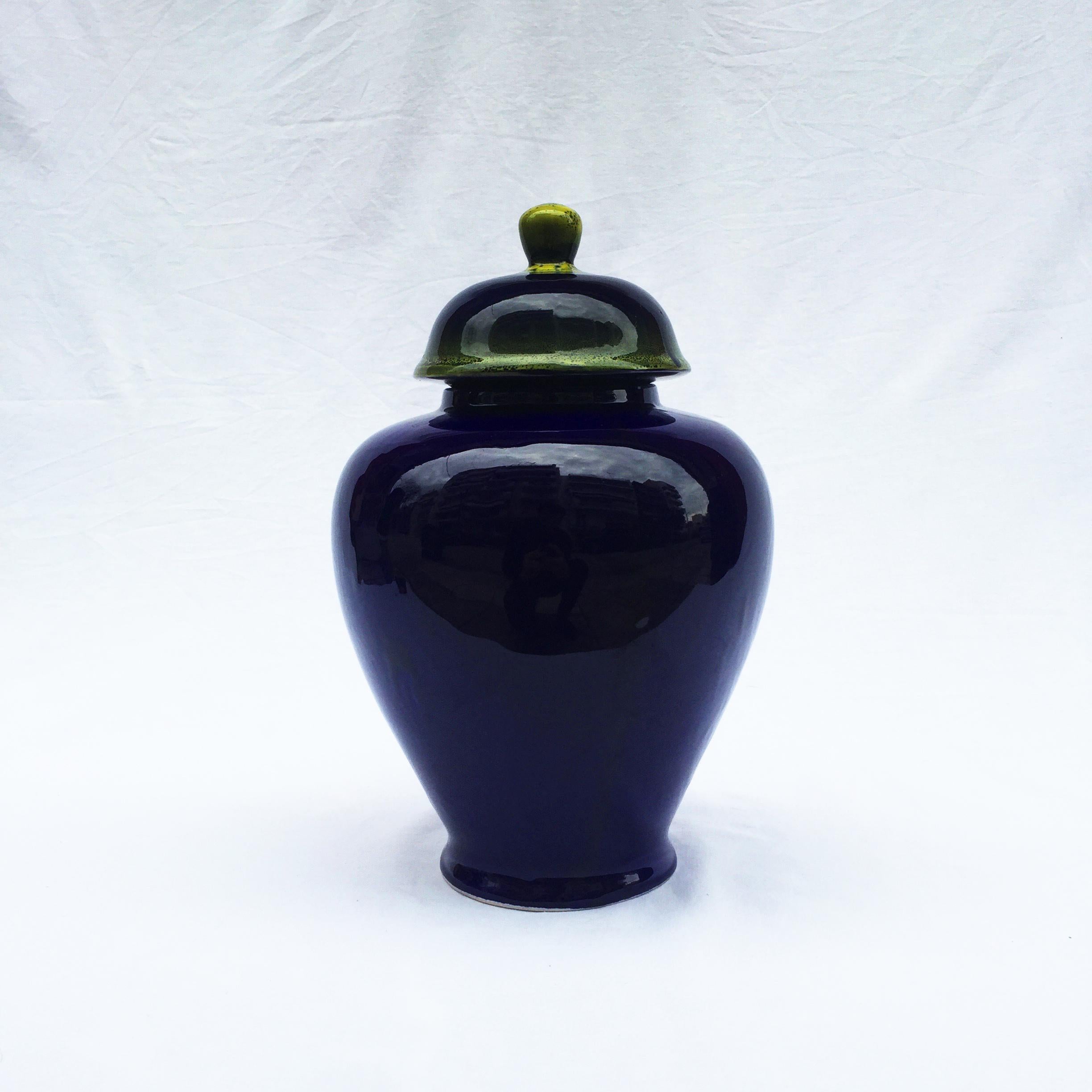 Handmade ceramic lidded vase in the form of a ginger jar. Navy blue glazed ceramic with shades of yellow on the lid. Imported and made in Greece during the 1980s. Listing is only for one more available on different designs.
  