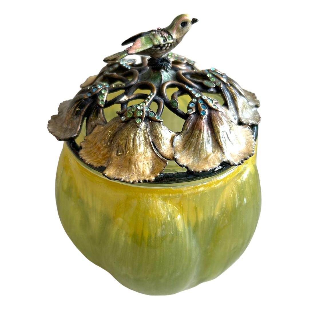 Excellent condition! beautiful green opaline jar designed by Jay Strongwater; a melon shaped jar; top covered by enameled ginkgo leaves with jeweled stems; a small jeweled bird perches at the top; a gem-like addition to a dressing table or as an