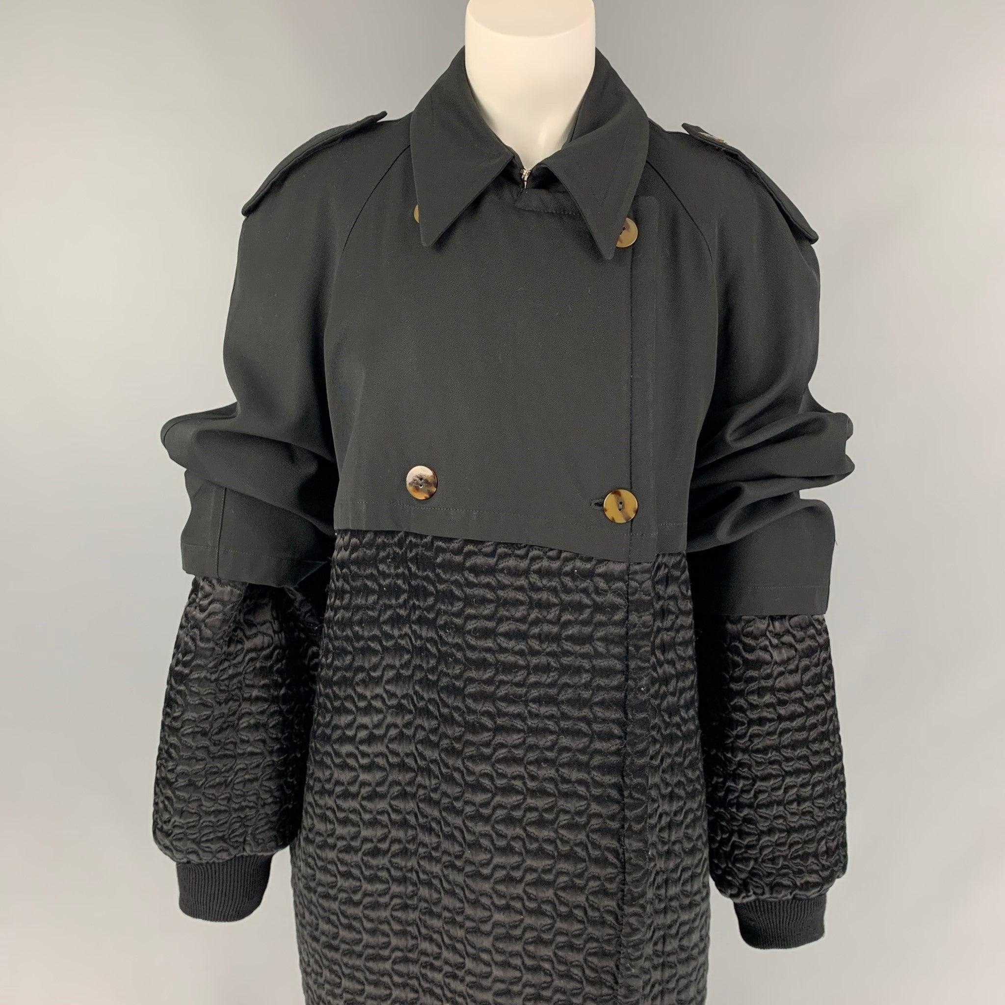 VINTAGE 1980's JEAN PAUL GAULTIER pour GIBO trench coat comes in a black quilted material with a full liner featuring a layered style, epaulettes, pointed collar, ribbed hem, slit pockets, and a double breasted closure. Early Gaultier Collectors