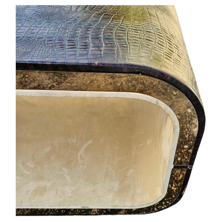  Vintage 1980s Karl Springer-Style Crocodile Leather Coffee Table

This stunning vintage coffee table, inspired by the iconic designs of Karl Springer, is a true statement piece from the 1980s. The table's exterior is wrapped in luxurious