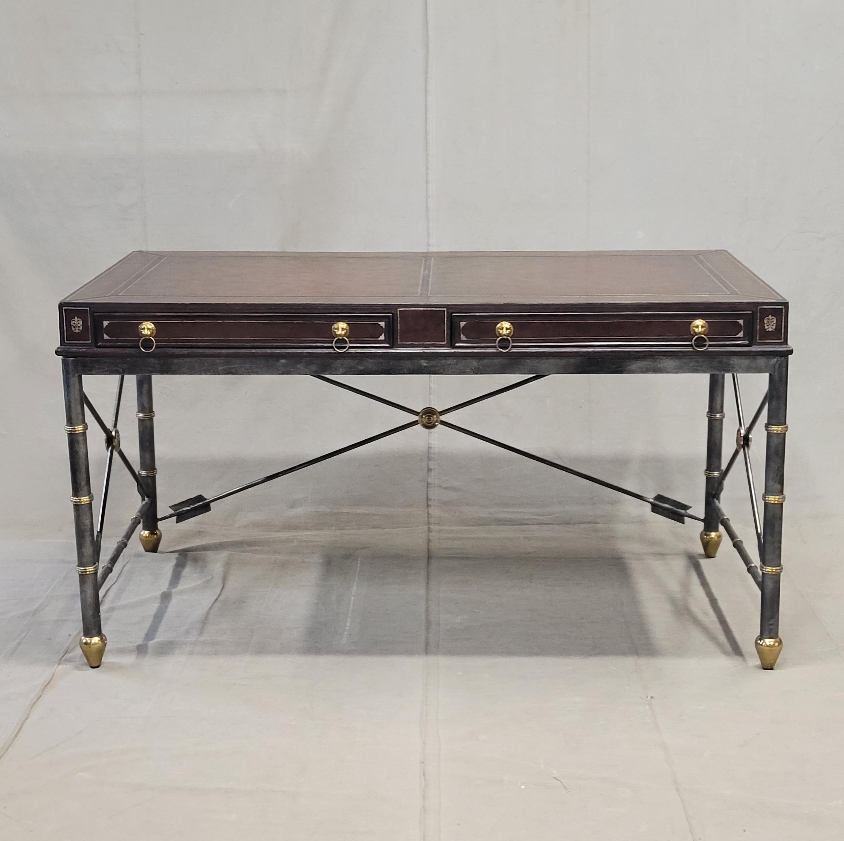 A beautiful vintage 1980s neoclassical style writing desk by Lineage Home Furnishings (a line within the Maitland Smith brand) expertly crafted out of wood, leather, iron and brass. The top is tooled brown leather with gold embossing and has two