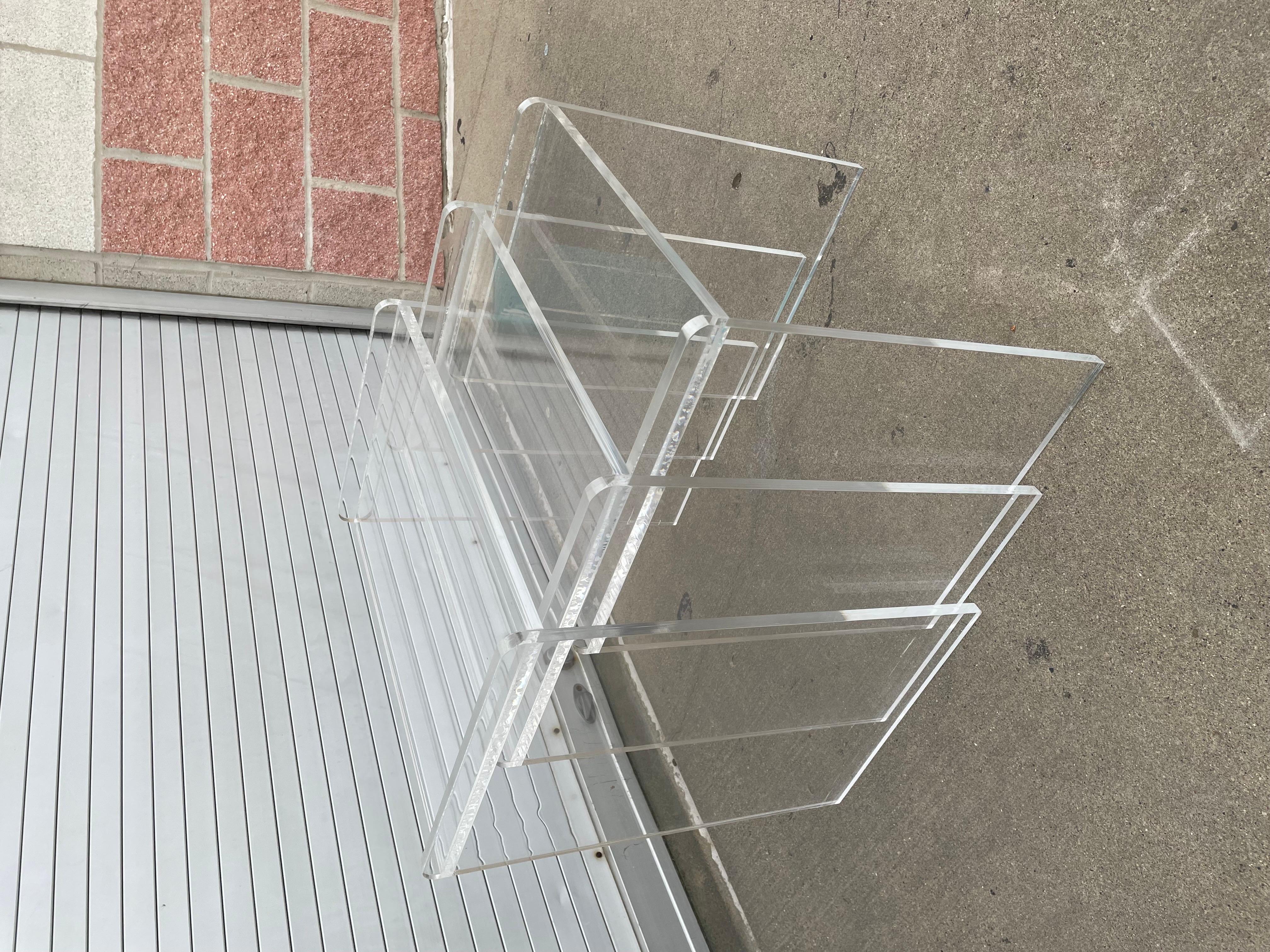 Gorgeous vintage lucite nesting tables set of three from the 80s stack on top of one another or can be used separately. Lucite tables feature top brim on the side edges giving the shape interesting touches. 

Small table: 15” L, 15” T, 12”