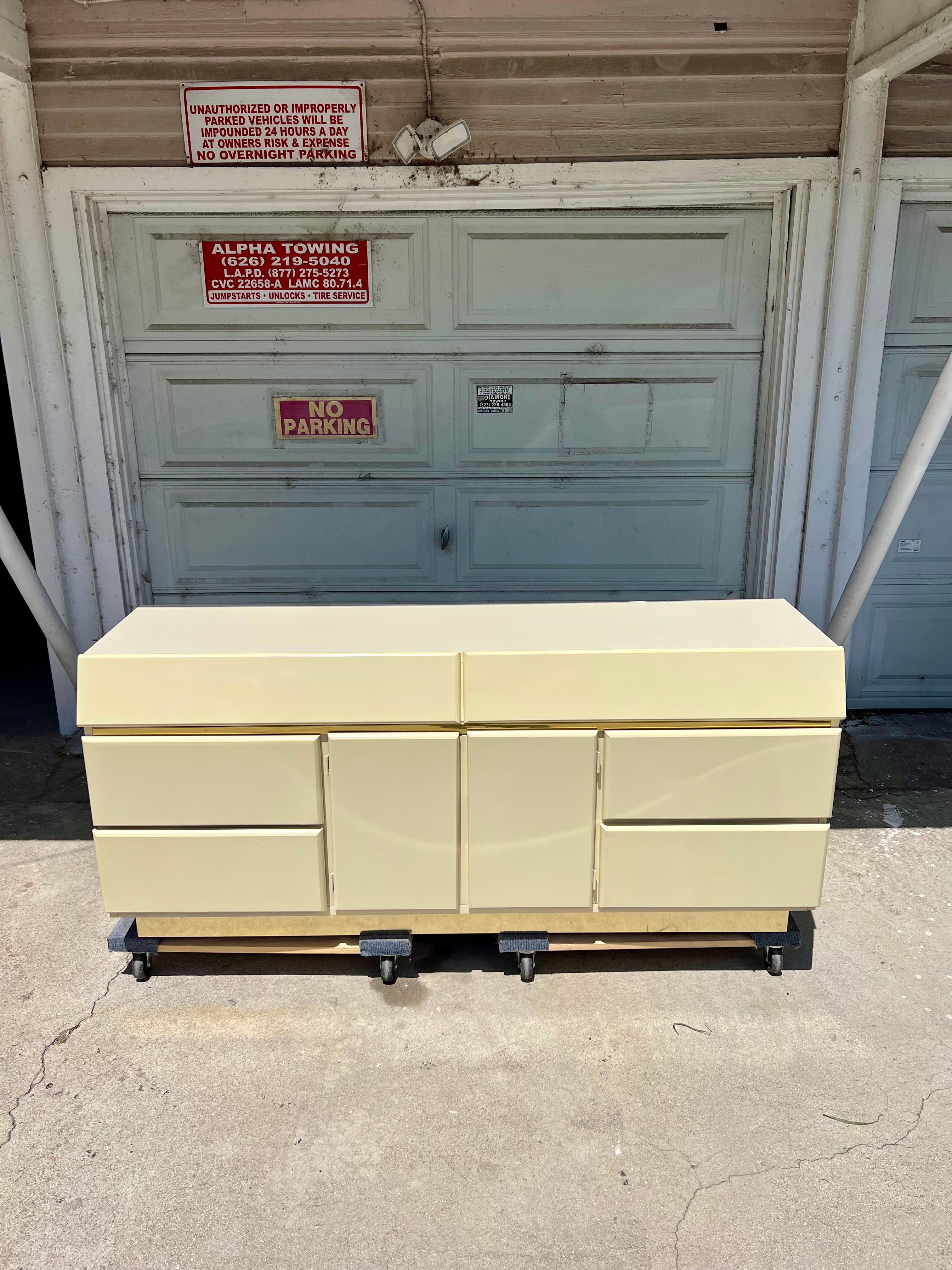 Excellent postmodern lacquered dresser with slant front top drawer. Overall excellent vintage condition. All wood drawer tracks slide well. Dresser is equipped with 8 drawers, 2 in the center behind doors, providing ample storage. Any small lacquer