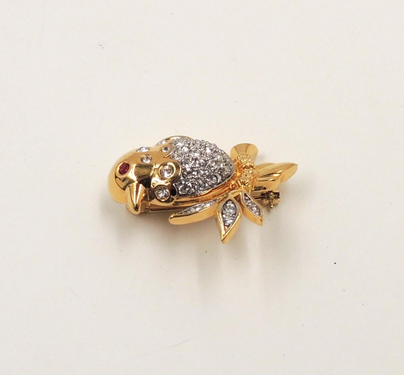 1980s gold plated pave clear rhinestone with faux-garnet eye bird on a branch brooch with security clasp. Marked 