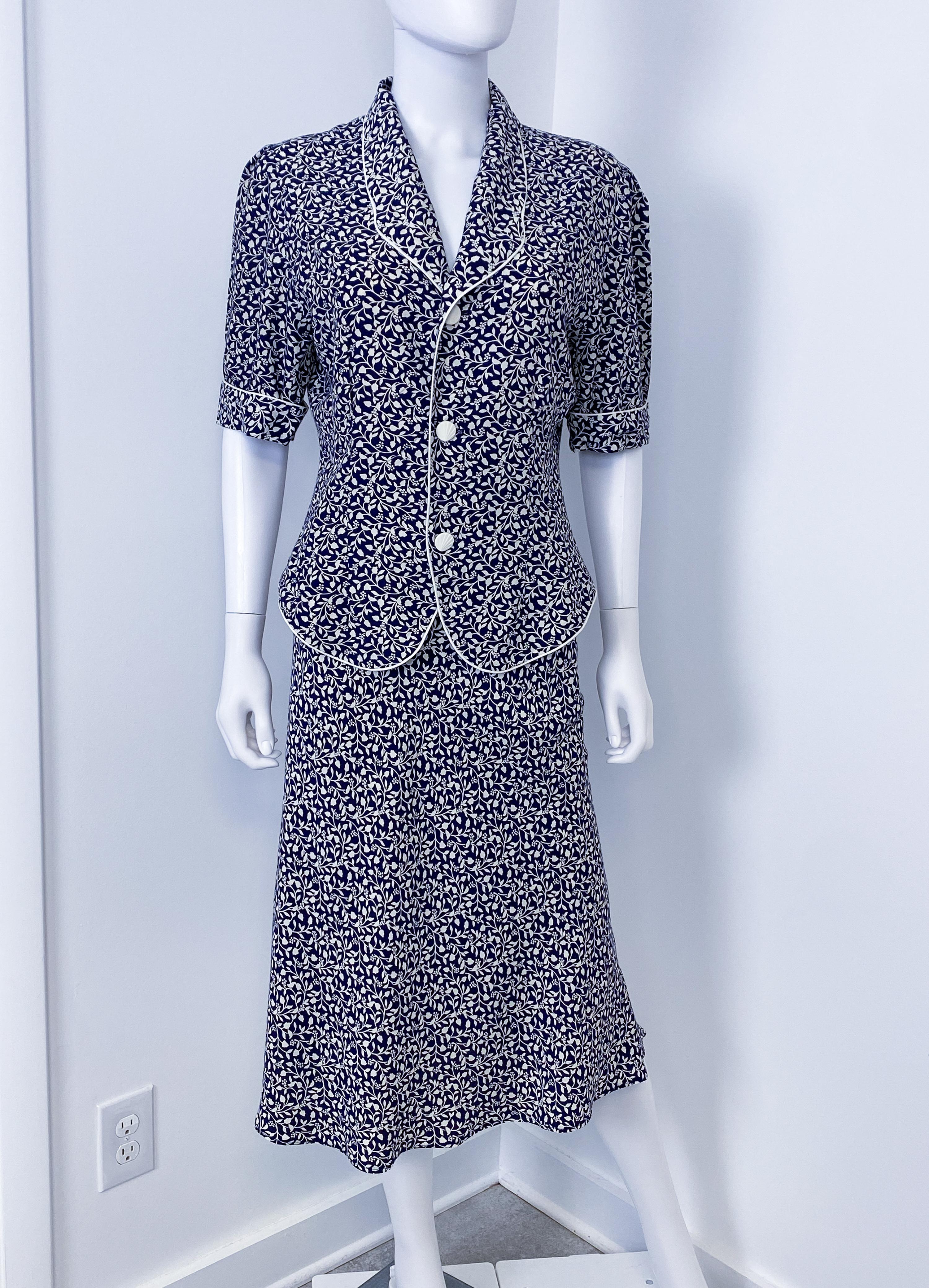 Ce ravissant tailleur jupe à manches courtes en viscose soyeuse des années 1980 est d'inspiration 1940. Le poids de la viscose confère à la jupe et à la veste un beau tombé et un éclat satiné. La jupe est droite et légèrement profilée, tombant sous