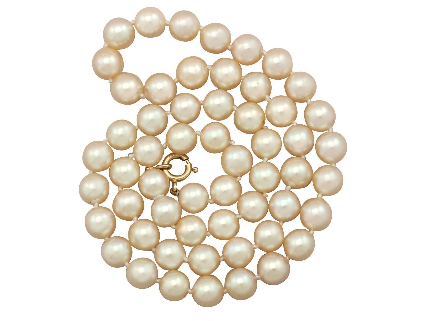 A fine and impressive single strand cultured pearl necklace with an 18 karat yellow gold clasp; part of our diverse vintage jewelry and estate jewelry collections.

This fine and impressive vintage single strand pearl necklace consists of fifty-six