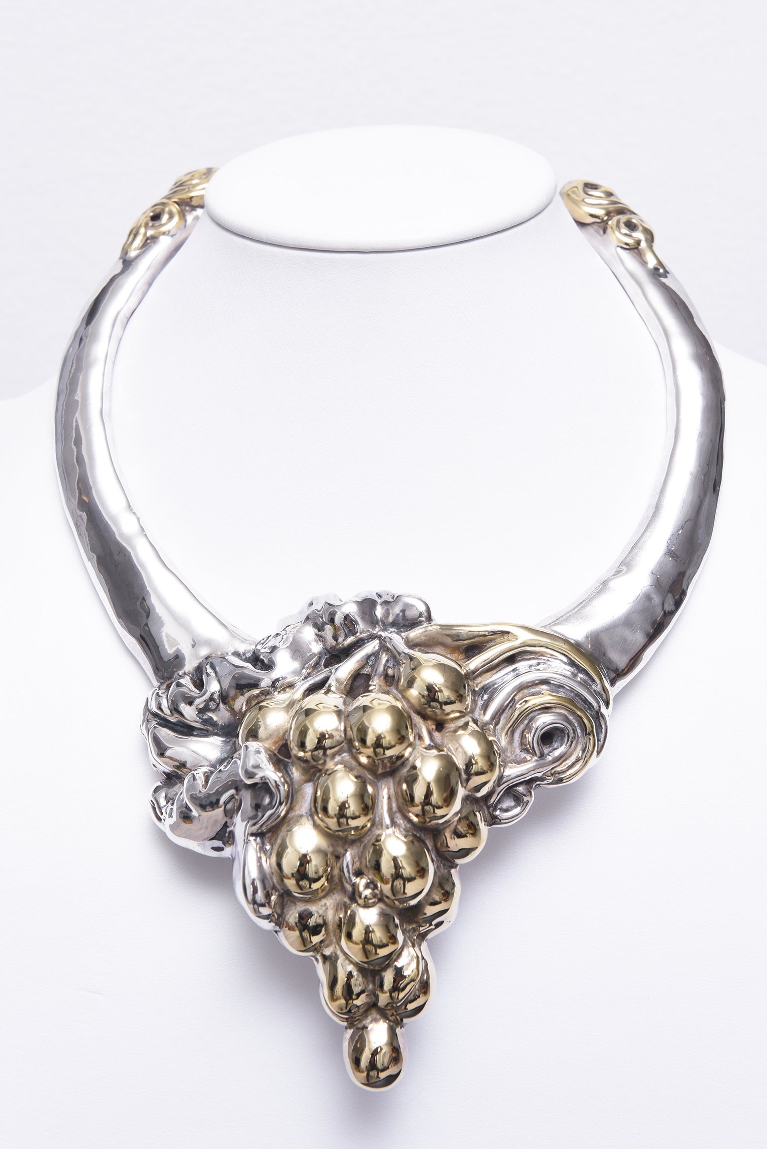 Collana israeliana d'argento e vermeil vintage del 1980. Questa splendida collana è realizzata in argento sterling. Il design è caratterizzato da un audace grappolo di sfere d'uva in tonalità oro al centro, con intricati dettagli vorticosi che lo