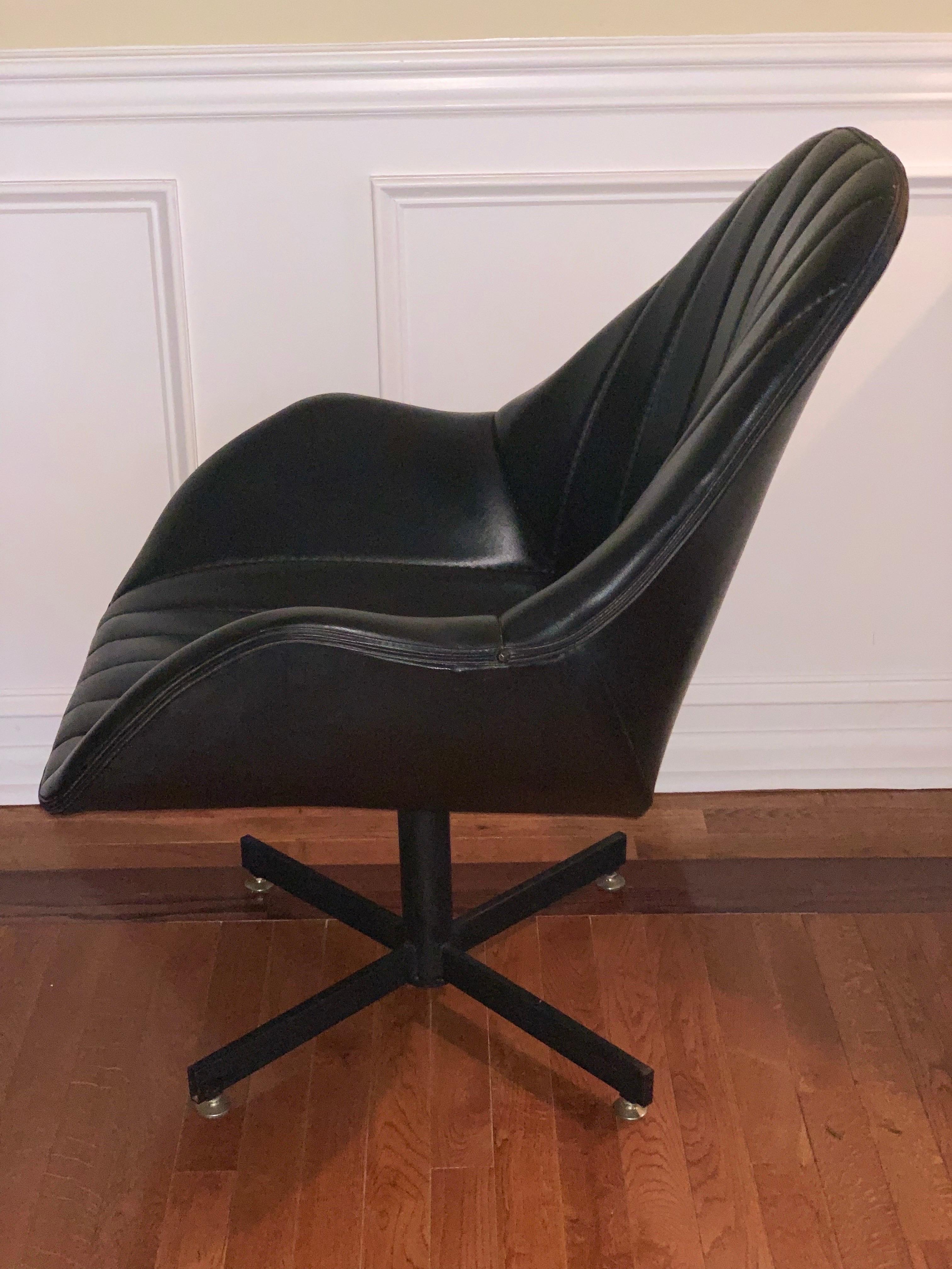 Handsome vintage 1980's Naugahyde swivel bucket lounge chair on a black metal base. Well made and comfortable with very little use noted. Chair swivels smoothly and easily. The seat and back are channel-tufted. 

This chair has an understated yet