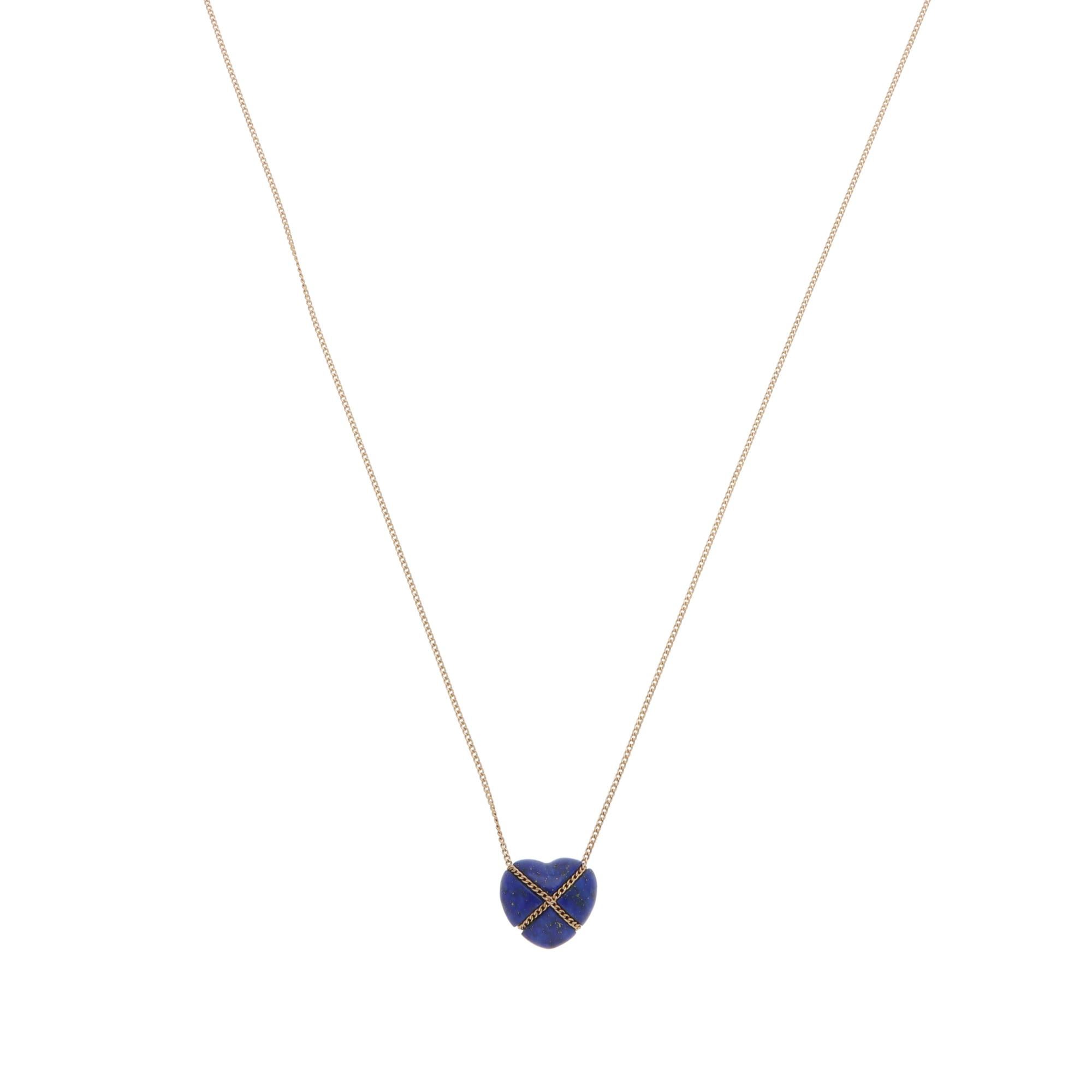 A stylish vintage Tiffany & Co. lapis lazuli heart necklace set in 14k yellow gold, circa 1980s.

From the discontinued collection, the pendant depicts a heart motif carved from deep blue lapis lazuli. It is hugged by a cross design with a yellow