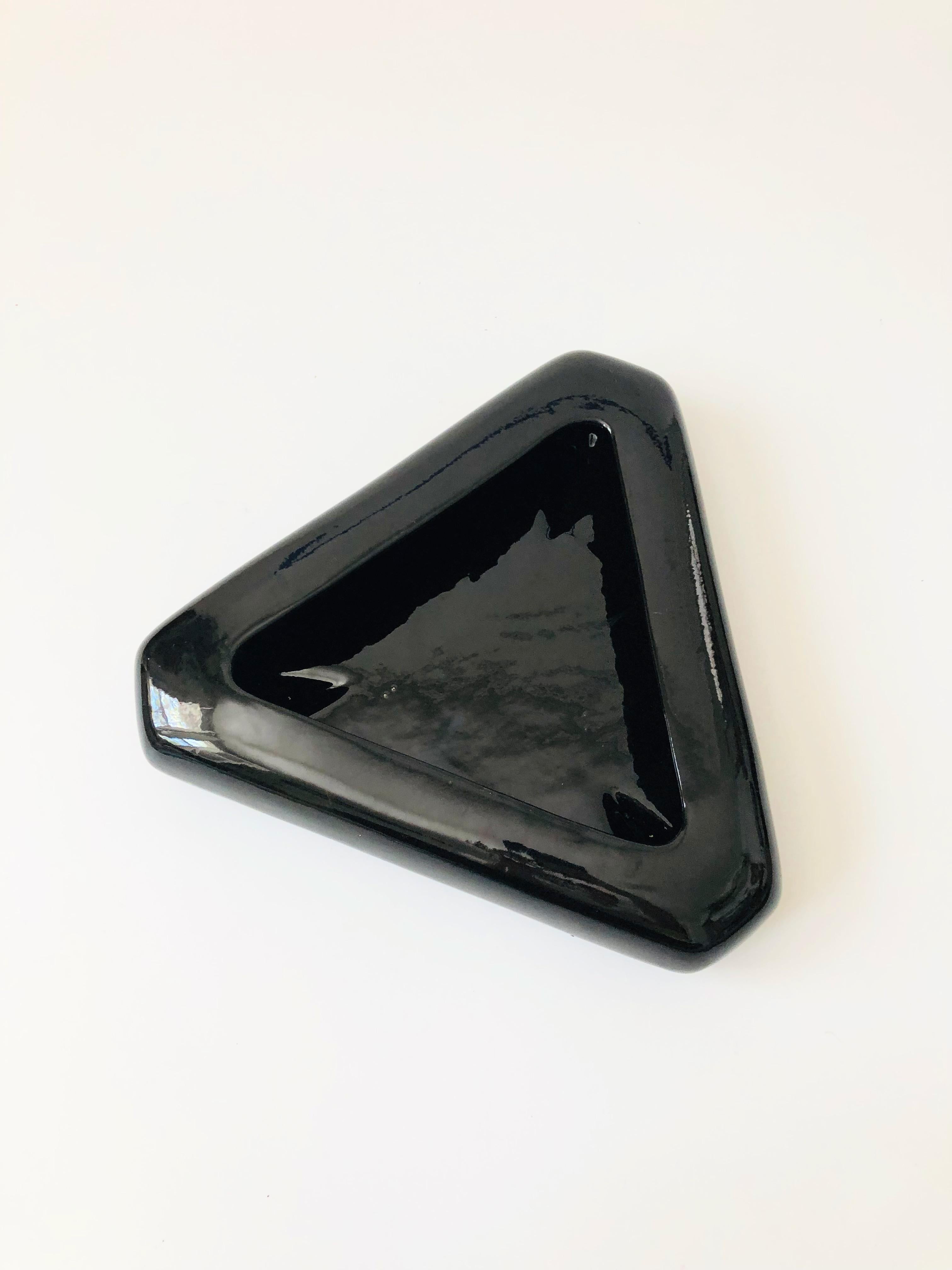 A vintage 1980s triangular ceramic tray. Nice large shallow size, finished in a glossy black glaze. Perfect for keeping small items in place or could be used as a shallow planter bowl. Made in the USA by Coronet Ceramics.
    