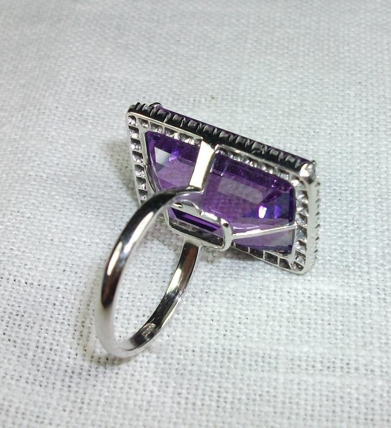 This is a fantastic, huge amethyst, 18k white gold and diamonds ring. The amethyst is so clear and transparent and the color is an intense violet/purple. The stone is surronded by diamonds which enhance its outstanding beauty. This ring looks