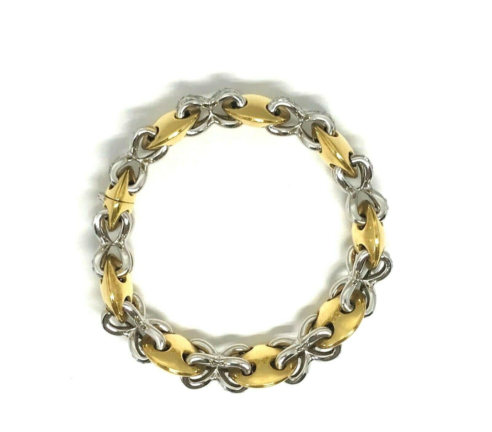 Vintage (c. 1980) bracelet en or 18k et diamants. Composé de formes de lentilles convexes en or jaune 18k reliées par des liens en or blanc 18k et diamants. Les diamants sont de taille ronde et brillante, de couleur G-H et de pureté VS1. Le poids